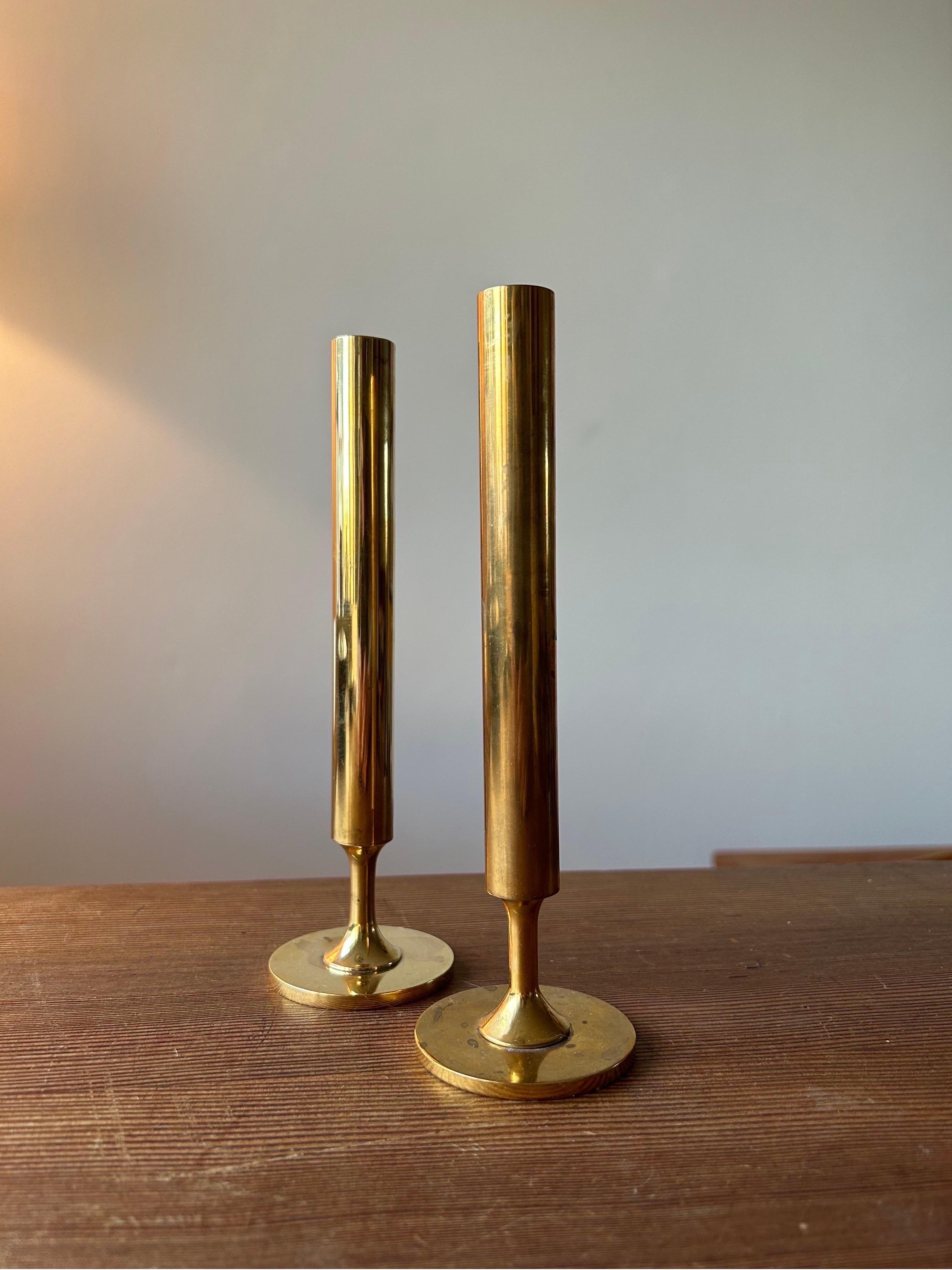 Pair of patinaed brass vases by Pierre Forssell for Skultuna.
Perfect set of vases for a single flower each or as a decorative object in the interior. 
The vases are made in solid brass which over the years has gotten a beautiful patina.

The