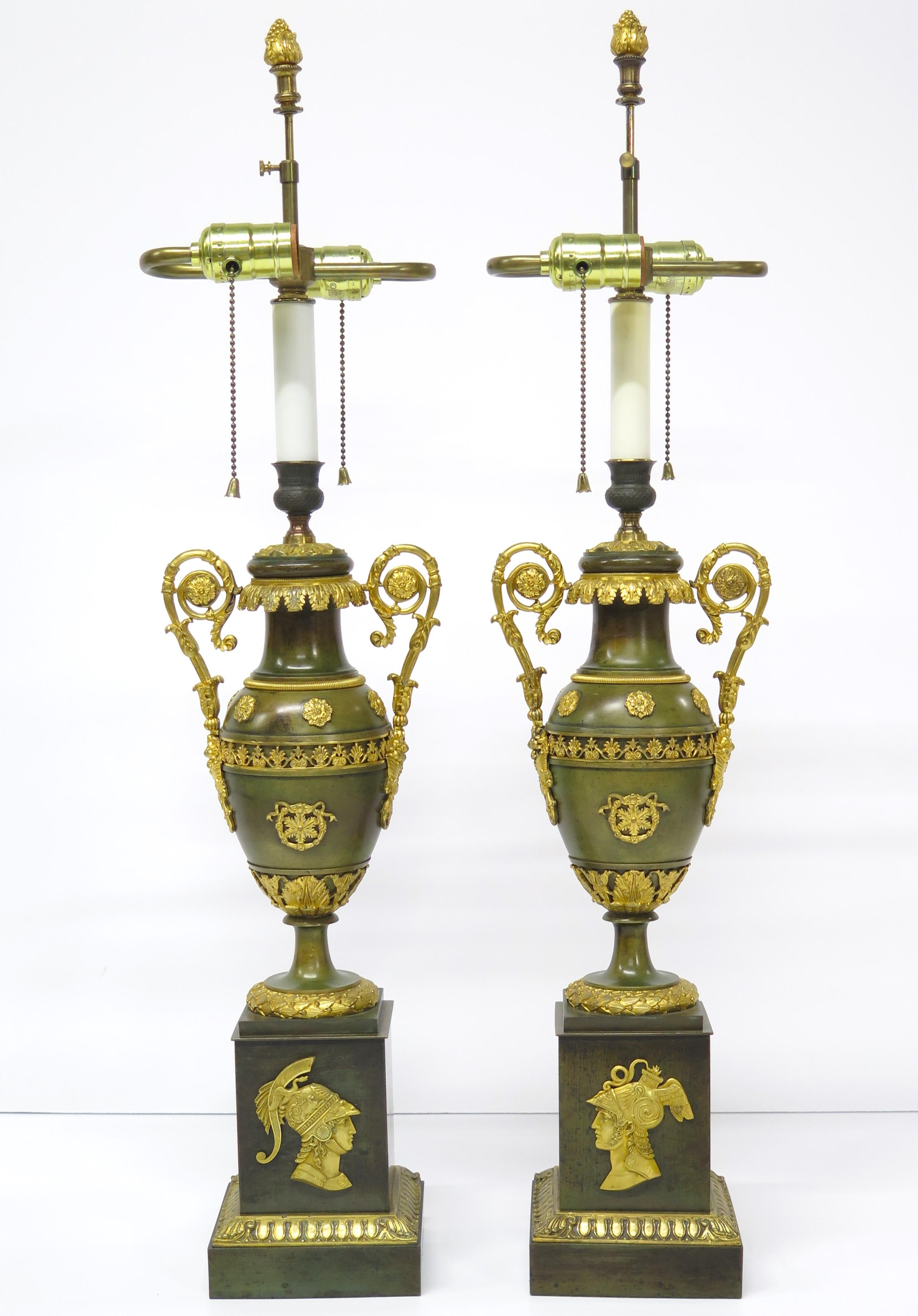 an exquisite French Empire pair of finely cast patinated and gilt bronze cassolettes now as custom lamps, rectangular plinth bases with ormolu / gilt bronze bas relief portrait profiles of Mars (Roman) and Perseus (Greek), support slender elegant