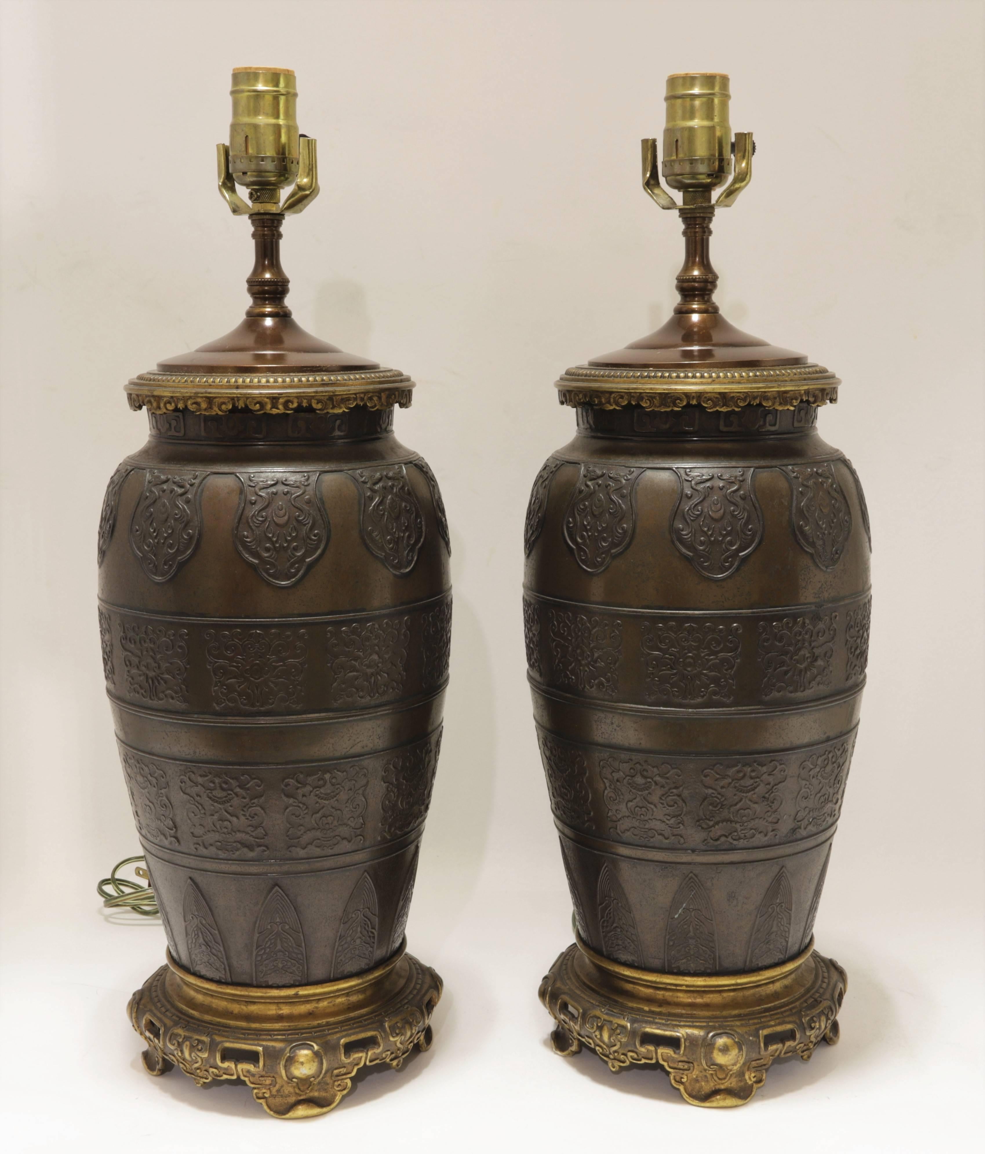 Pair of patinated and gilt bronze lamps in Chinese taste attributed to Caldwell & Co.