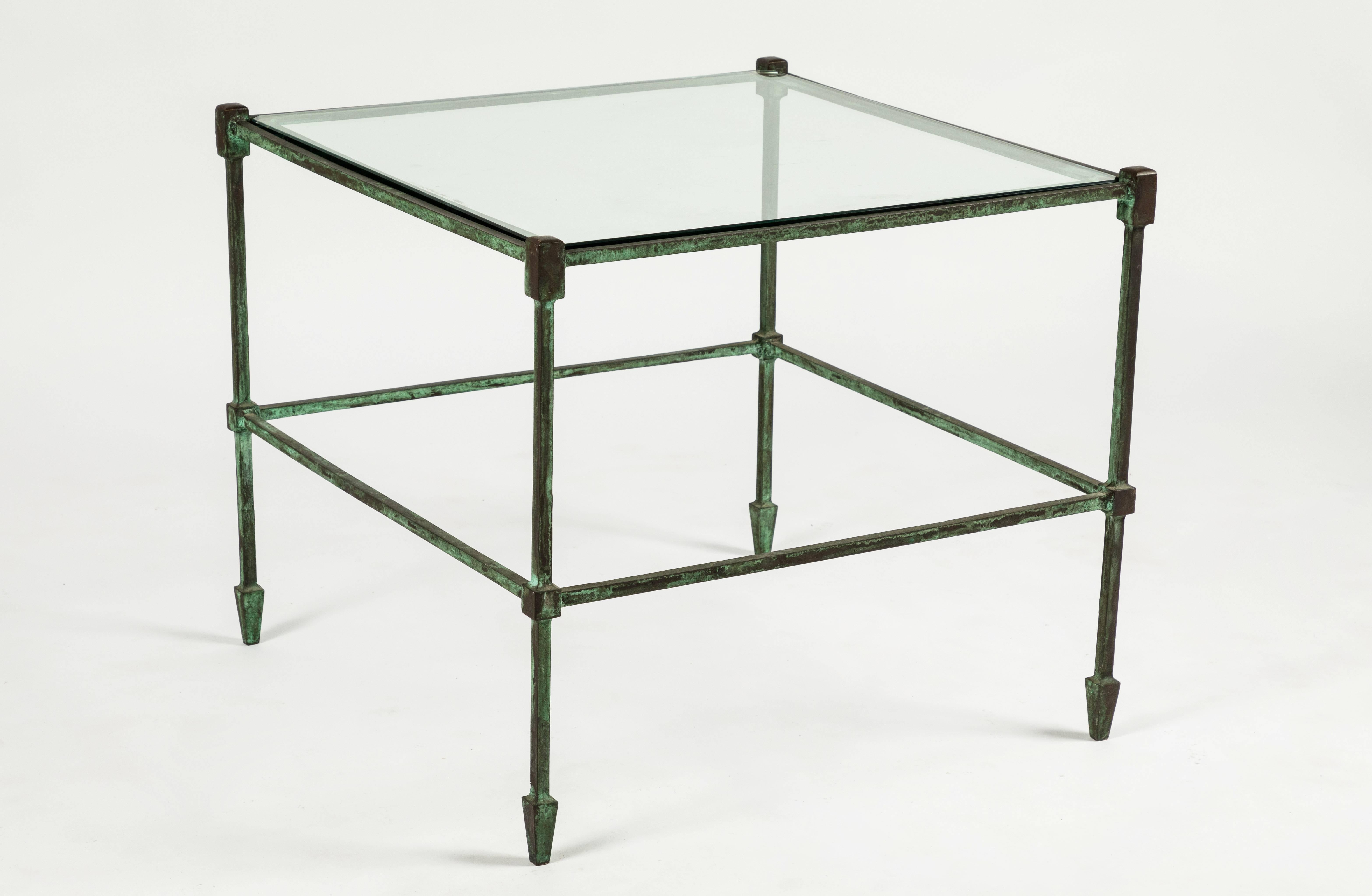 Super chic two-tired side tables featuring a patinated bronze frame with two glass shelves. Given the simplicity of the design of these tables they lend themselves to any number of interior styles. Glass appears to be original and therefore may have