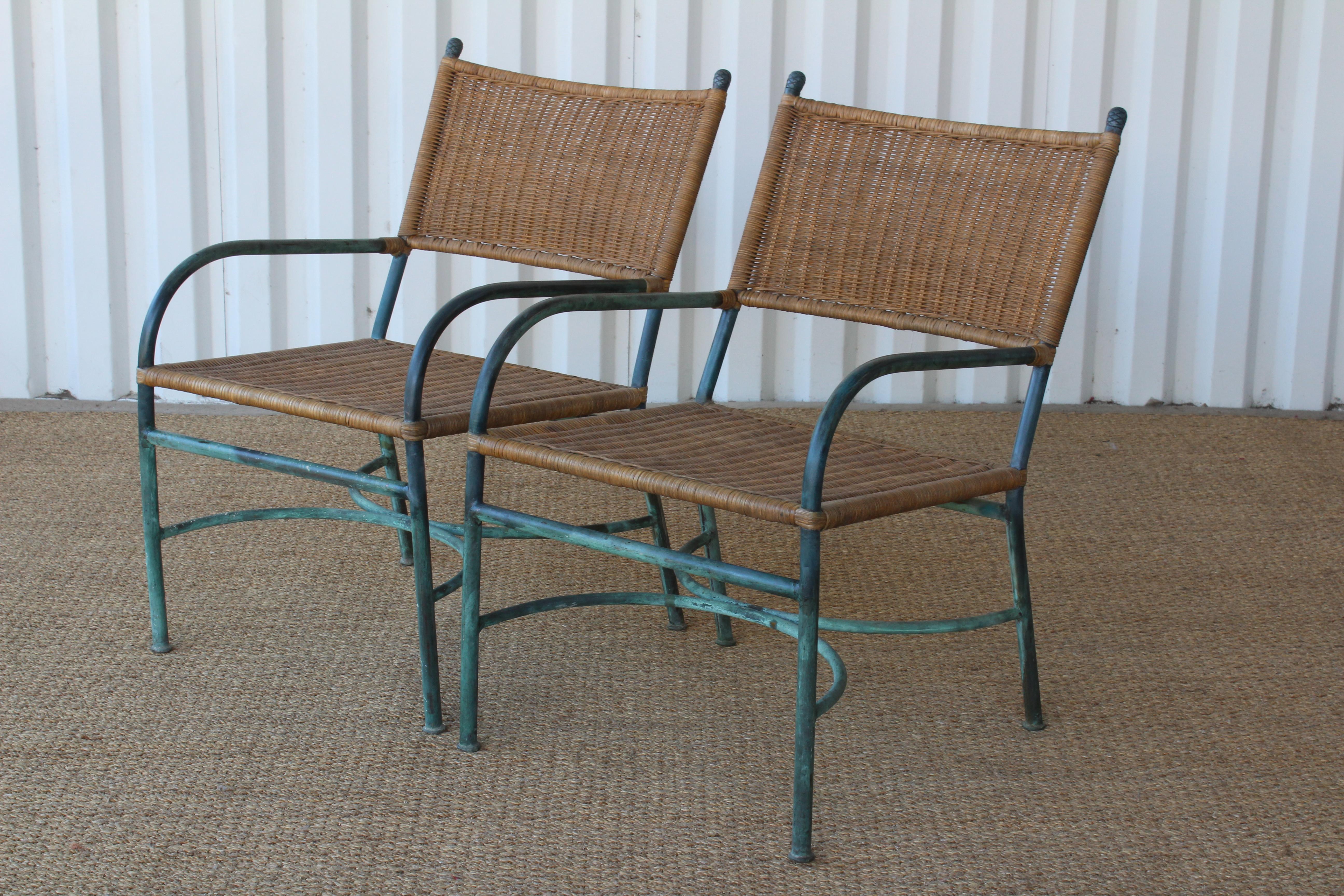 Pair of bronze armchairs with original heavy verdigris patina in the style of Walter Lamb. Each chair has new handwoven wicker.