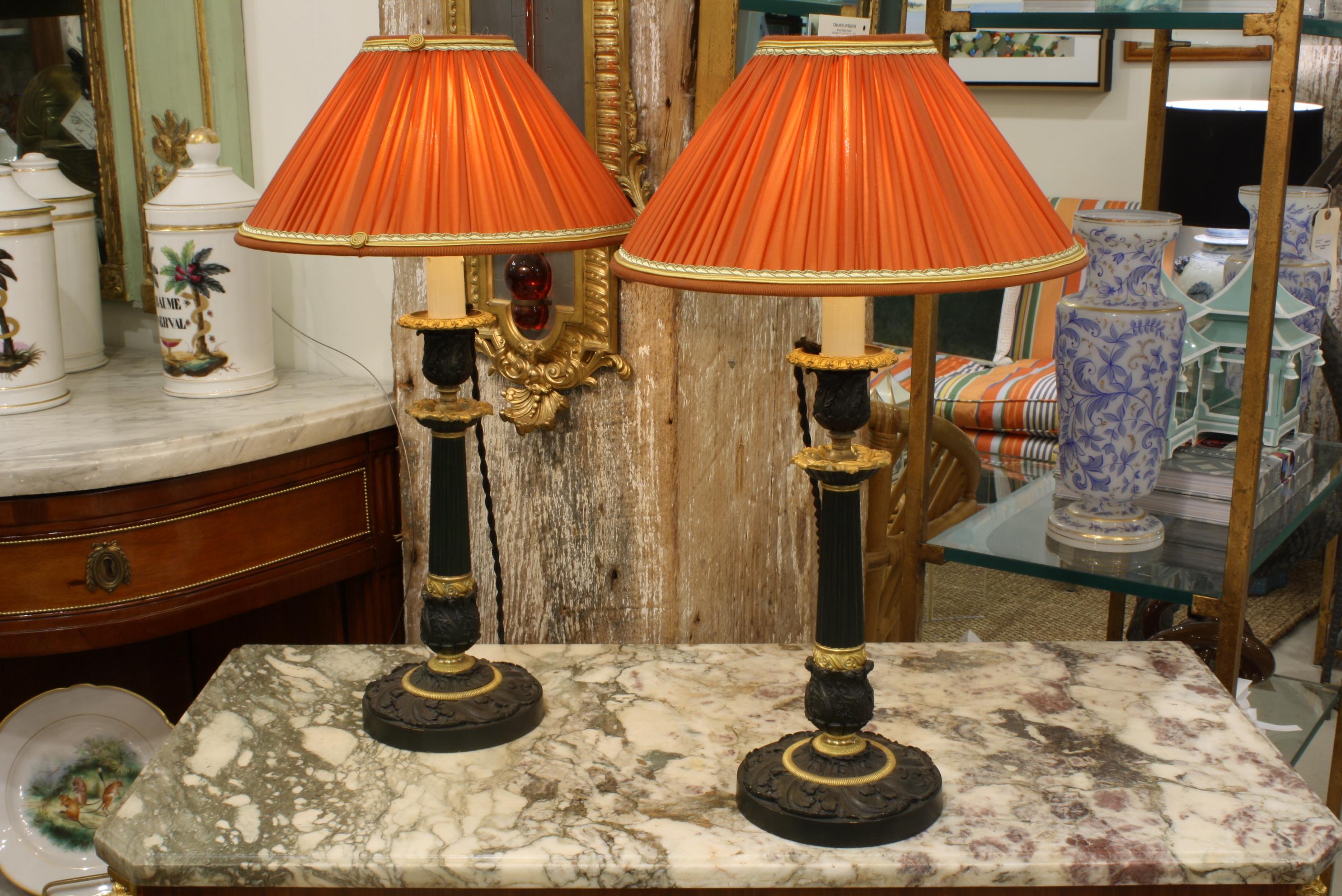 Zwei hübsche französische Leuchter aus vergoldeter und patinierter Bronze im Stil der Restauration aus dem 19. Die Kerzenhalter wurden als Lampen verdrahtet und mit plissierten orangefarbenen Seidenschirmen mit Verzierungen und Schnecken