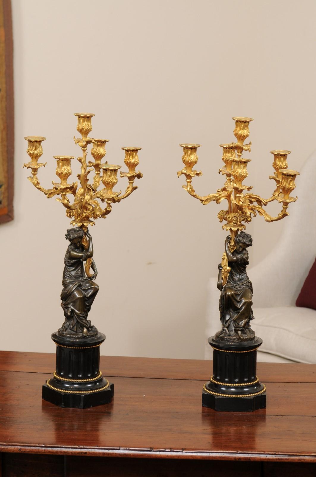 Pair of 19th century candelabra featuring patinated bronze female figures on onyx bases with six (6) ormolu candle holders, France.