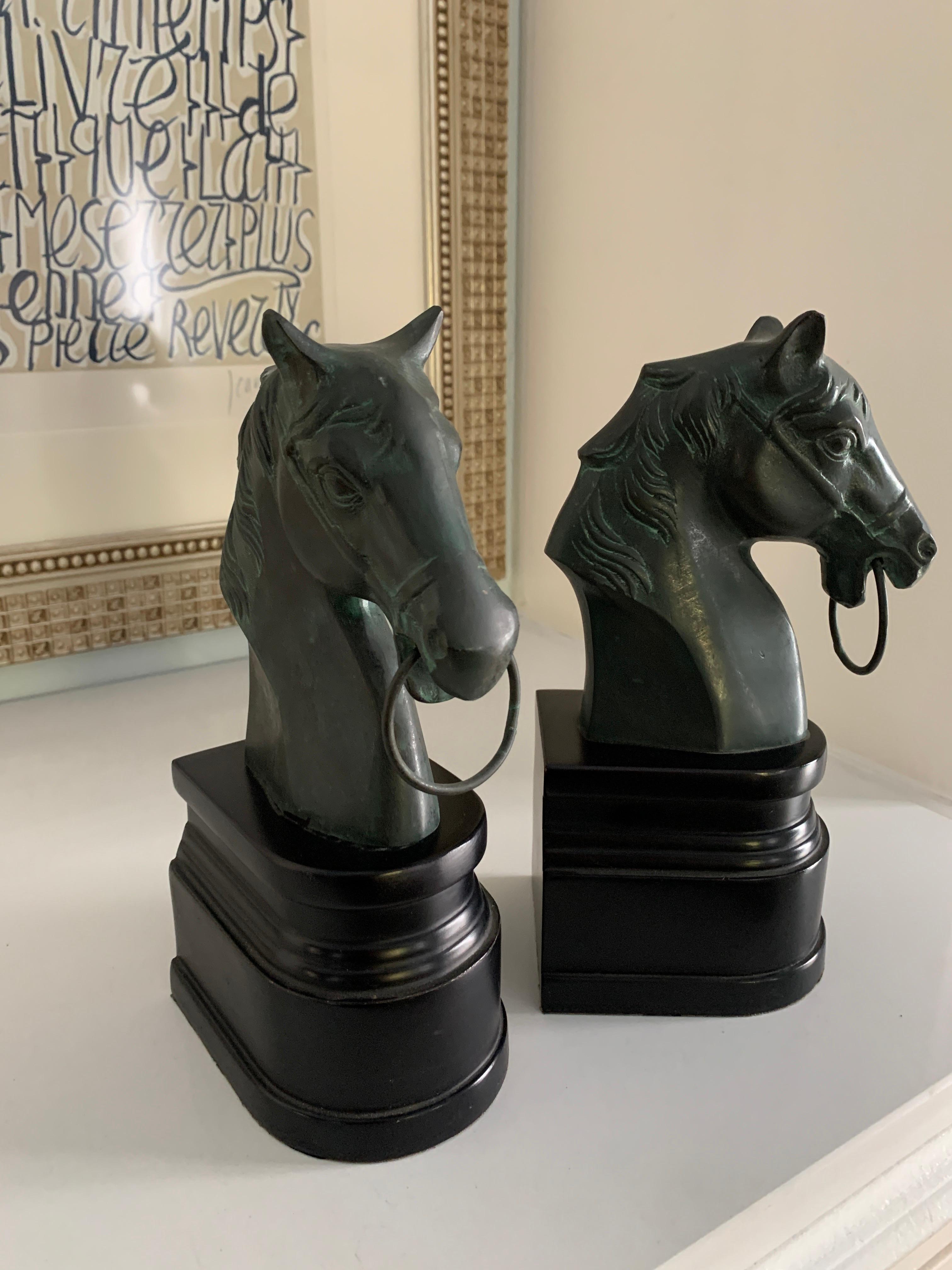 Pair of horse head bookends on stand - The wonderful pair have a patinated bronze top with a ring through the horse nose and black bases. A handsome pair, perfectly suited for the office, den or equestrian aficionado. The pair are reminiscent of
