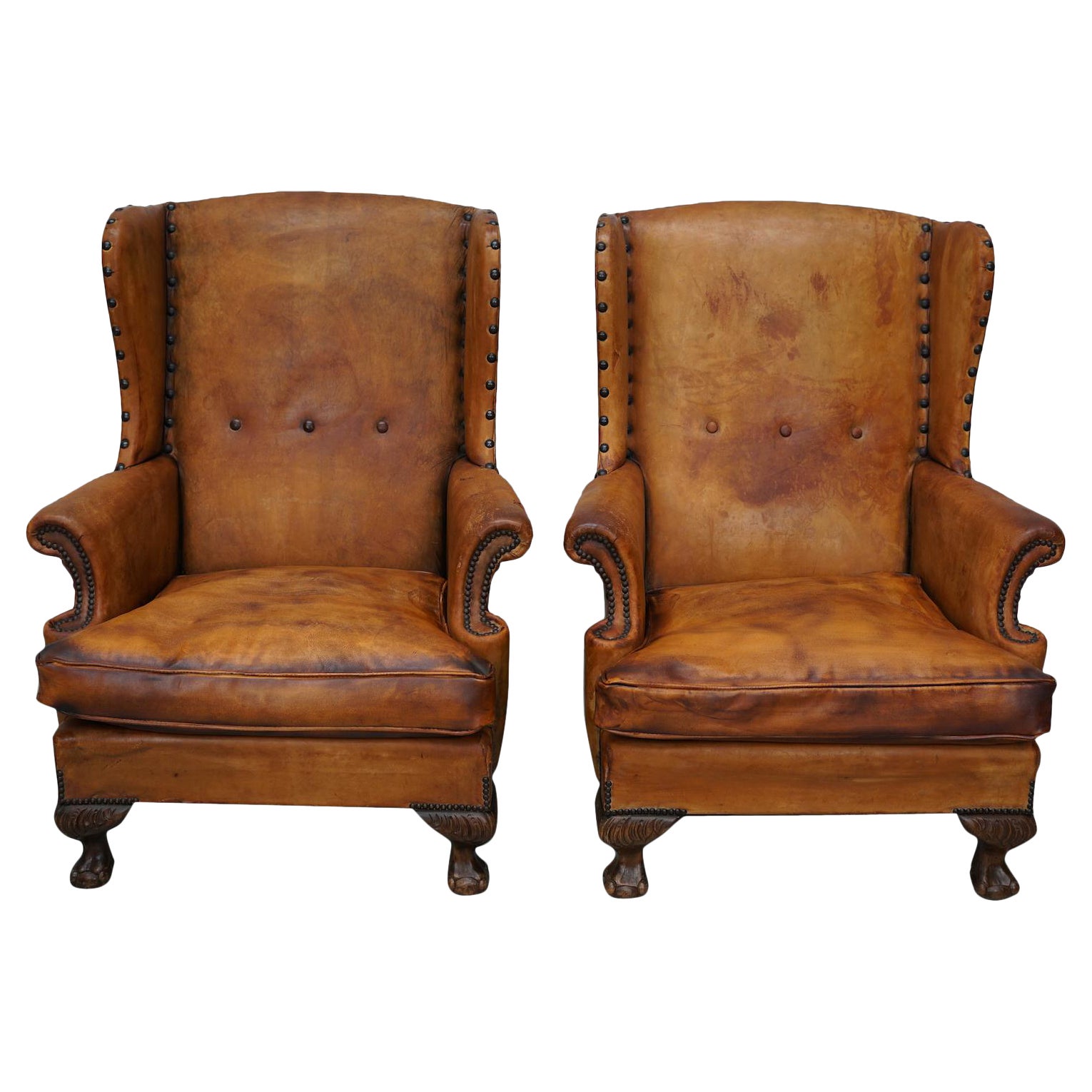 Paire de fauteuils club en cuir cognac patiné à dossier de type hollandais en vente
