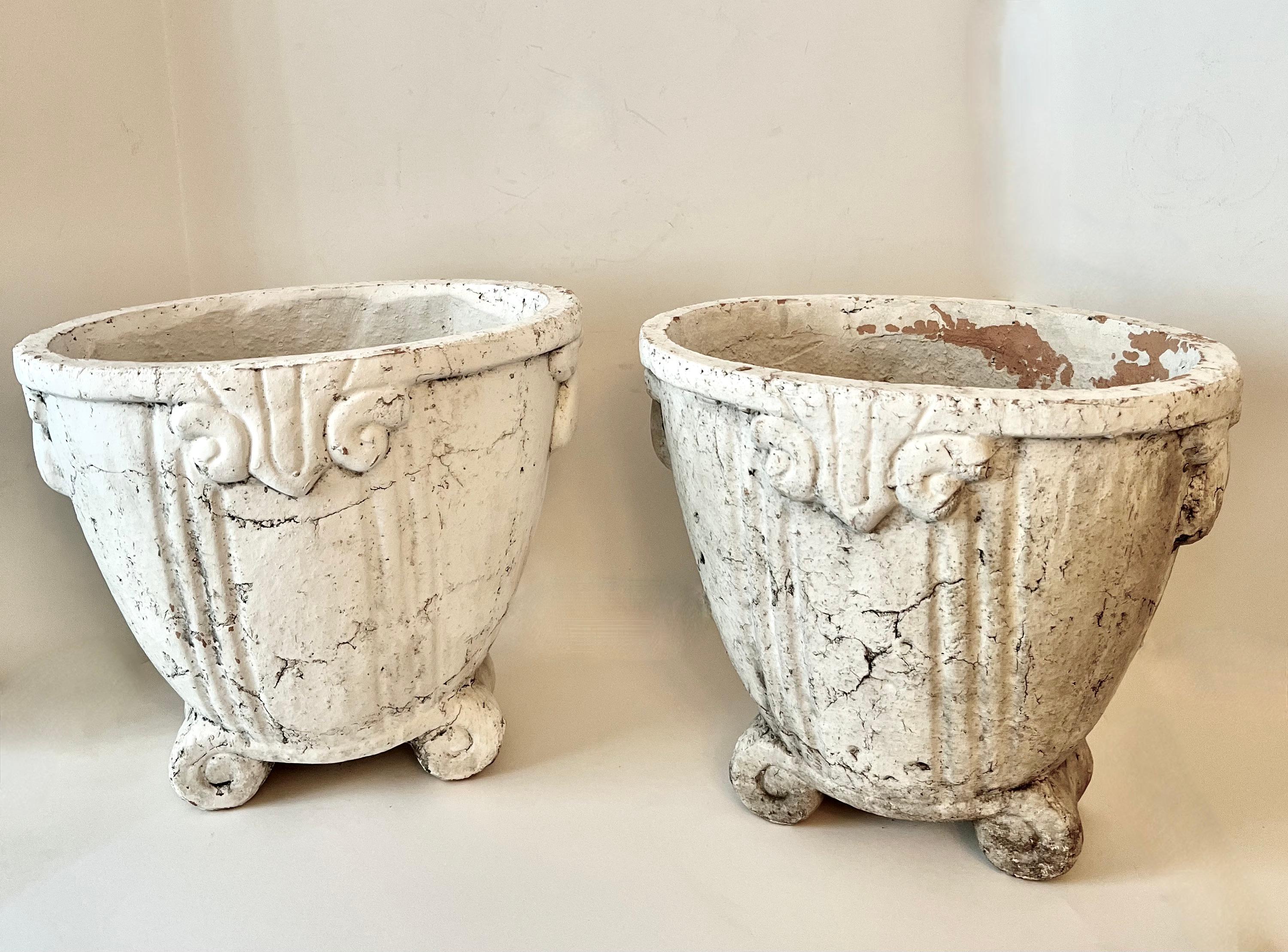 A pair of French terracotta planters or jardinieres.  The pair were painted some time ago and have a wonderful patina.  They look to have an art deco pattern and would be a compliment to an entry to a home or the garden.  

They would make lovely