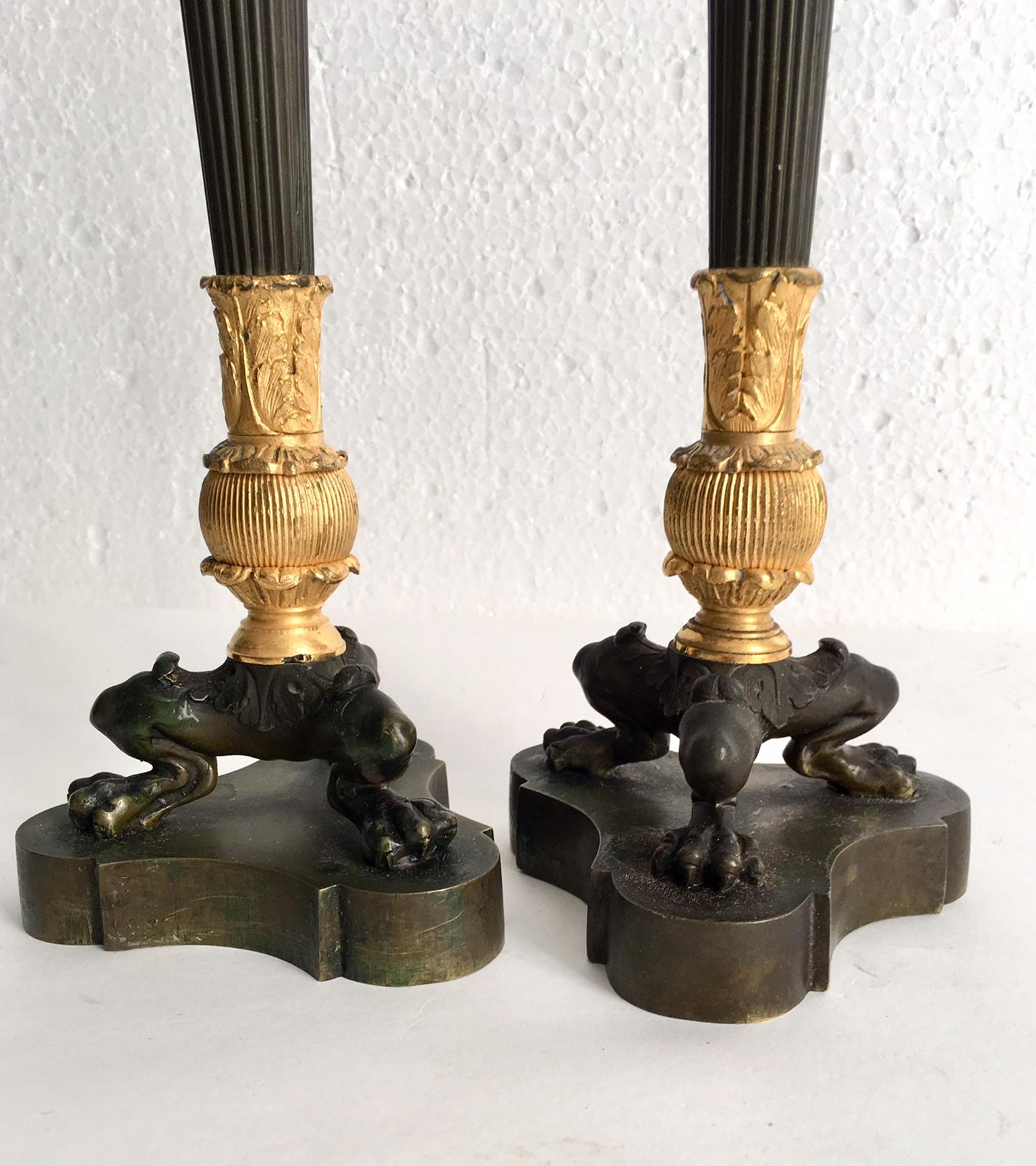 Pair of very elegant French Empire candlestick, classically influenced with fluted columns, and topped with urns, tripod of lion paw feet.