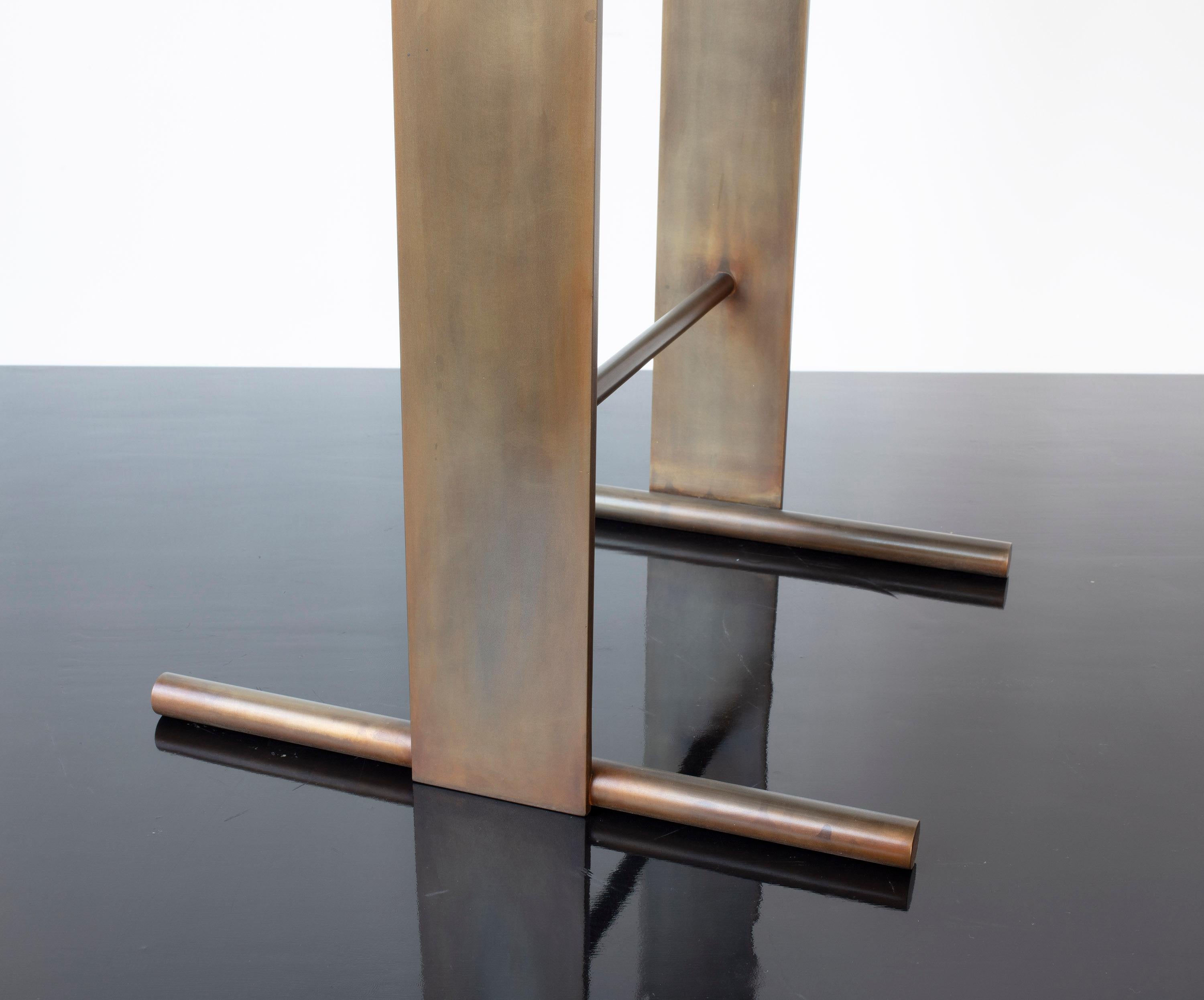 End tables in a solid steel construction with cleanly joined edges and well concealed welds.  The suspended lever design is a play on lightness and visual illusion in a solid metallic form.  Mesmerizing hand-rubbed patina creates incredible visual