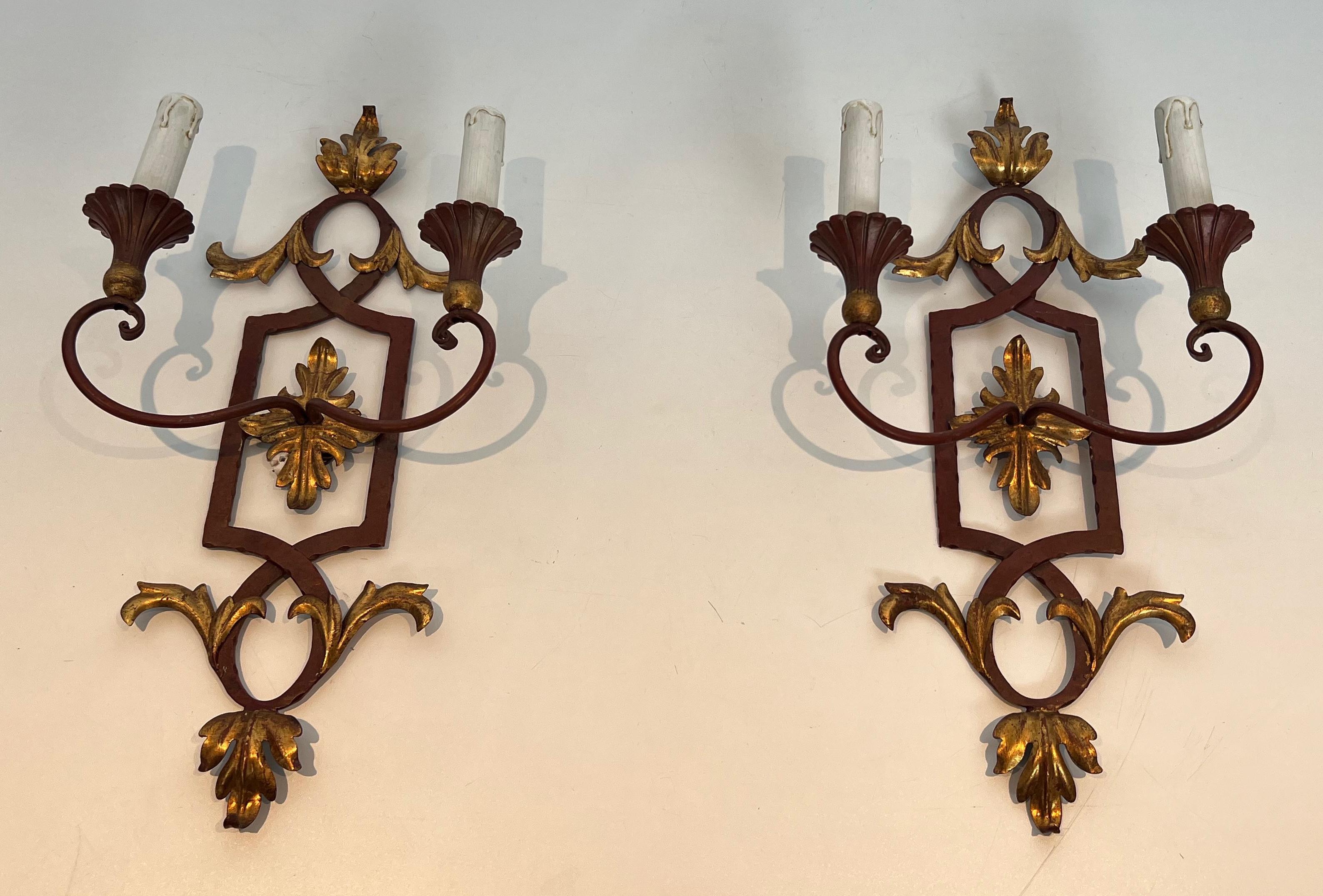 Este bonito par de apliques de pared es de hierro forjado patinado en rojo y madera con hojas de acanto doradas. Se trata de una obra francesa. Alrededor de 1940