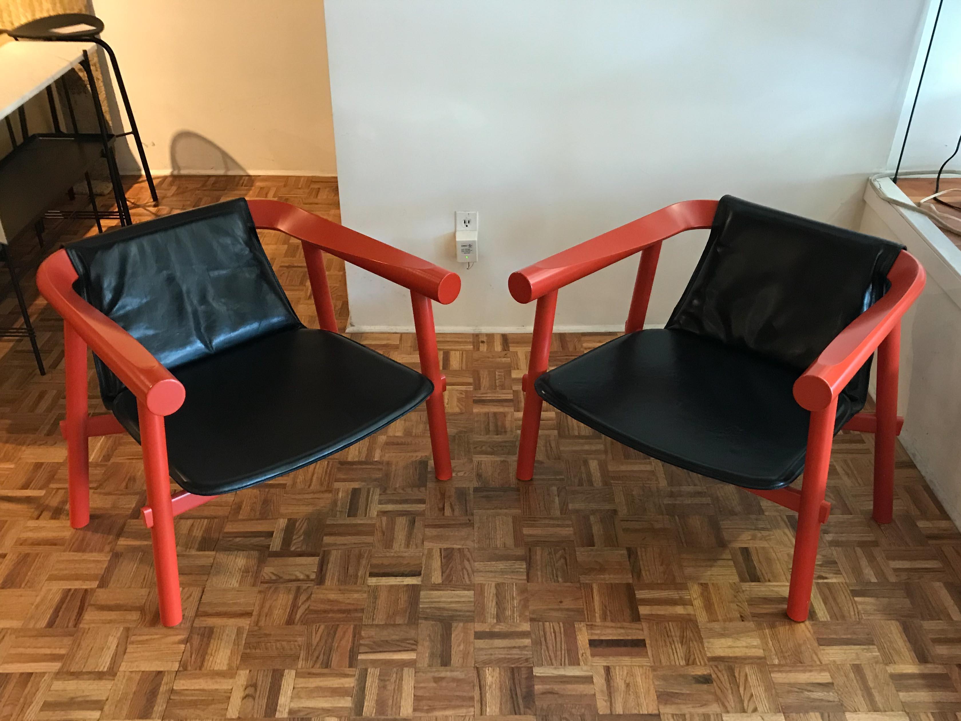 Pair of log chairs by Patricia Urquiola for Artelano, comprised of a solid beech frame in a lacquered orange finish with a seat made of black full-grain leather. Very good vintage condition, minor wear consistent with age and use, small chip in