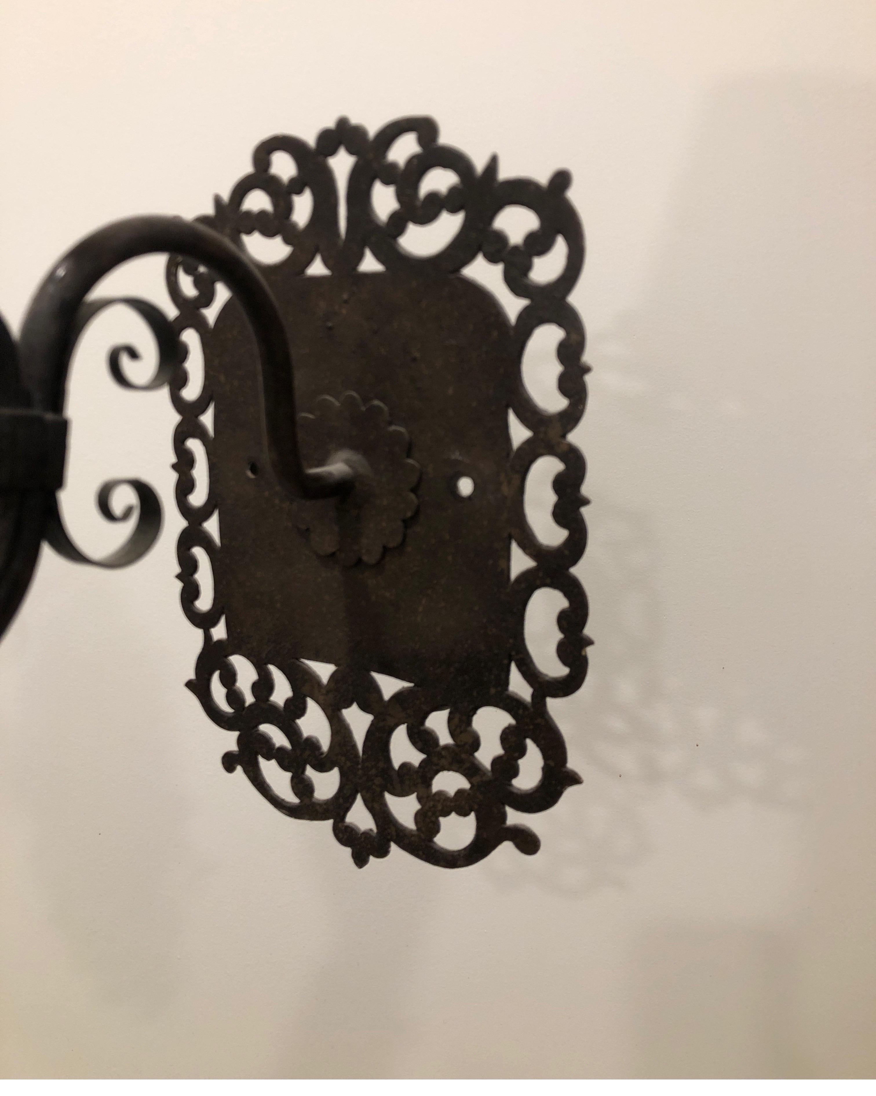 Two Pairs of Paul Ferrante iron sconces available. (We have a single 5th sconce available if needed)
Solid iron with one single light at the top. These sit off the wall about an Inch with a circle behind the rectangular backplate. 

See images