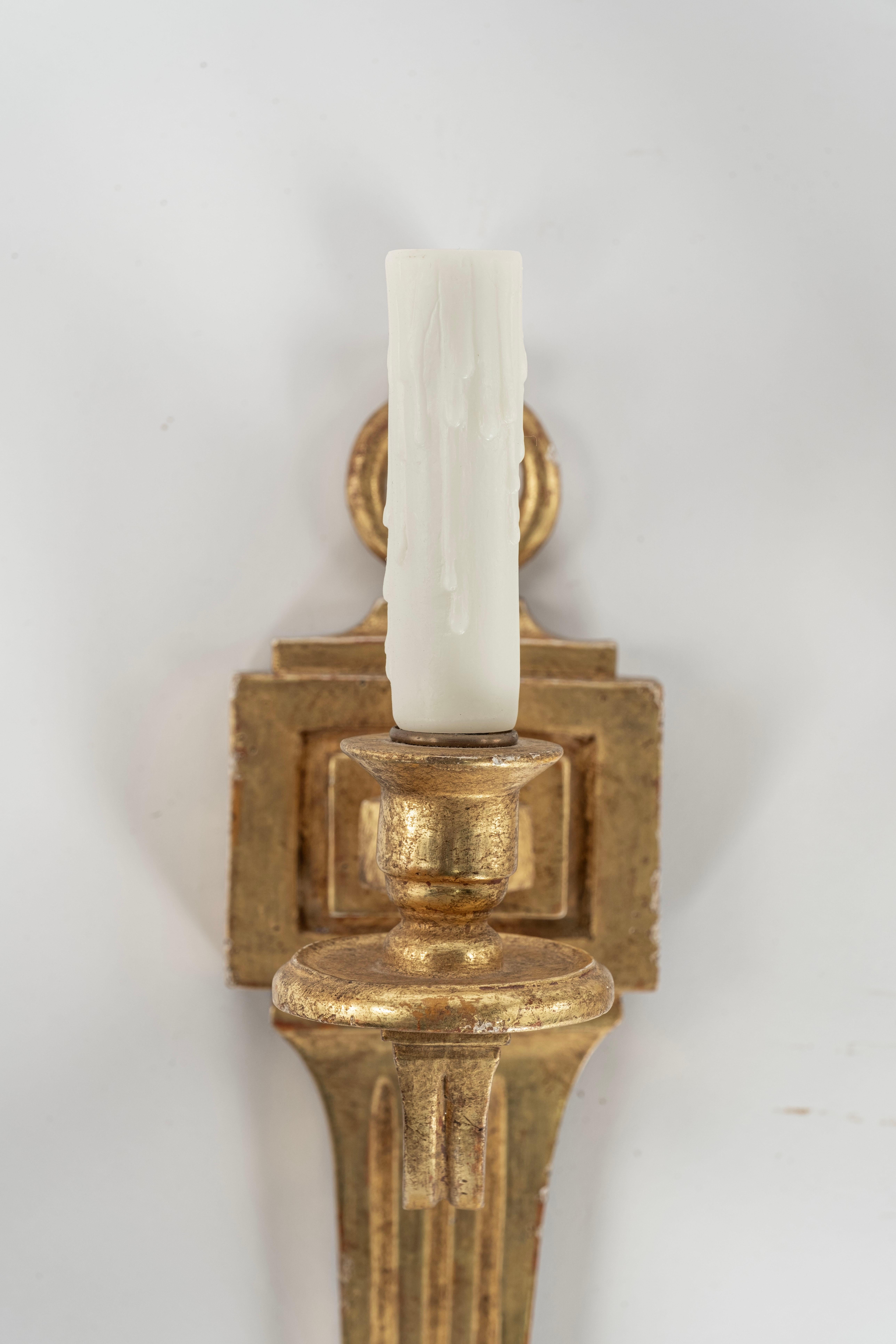  Pair of Sconces by Paul Ferrante in 22 Karat Gold with a single light on each one. 60 watts max per bulb.  If a shade is added the following size is recommended:  3.5