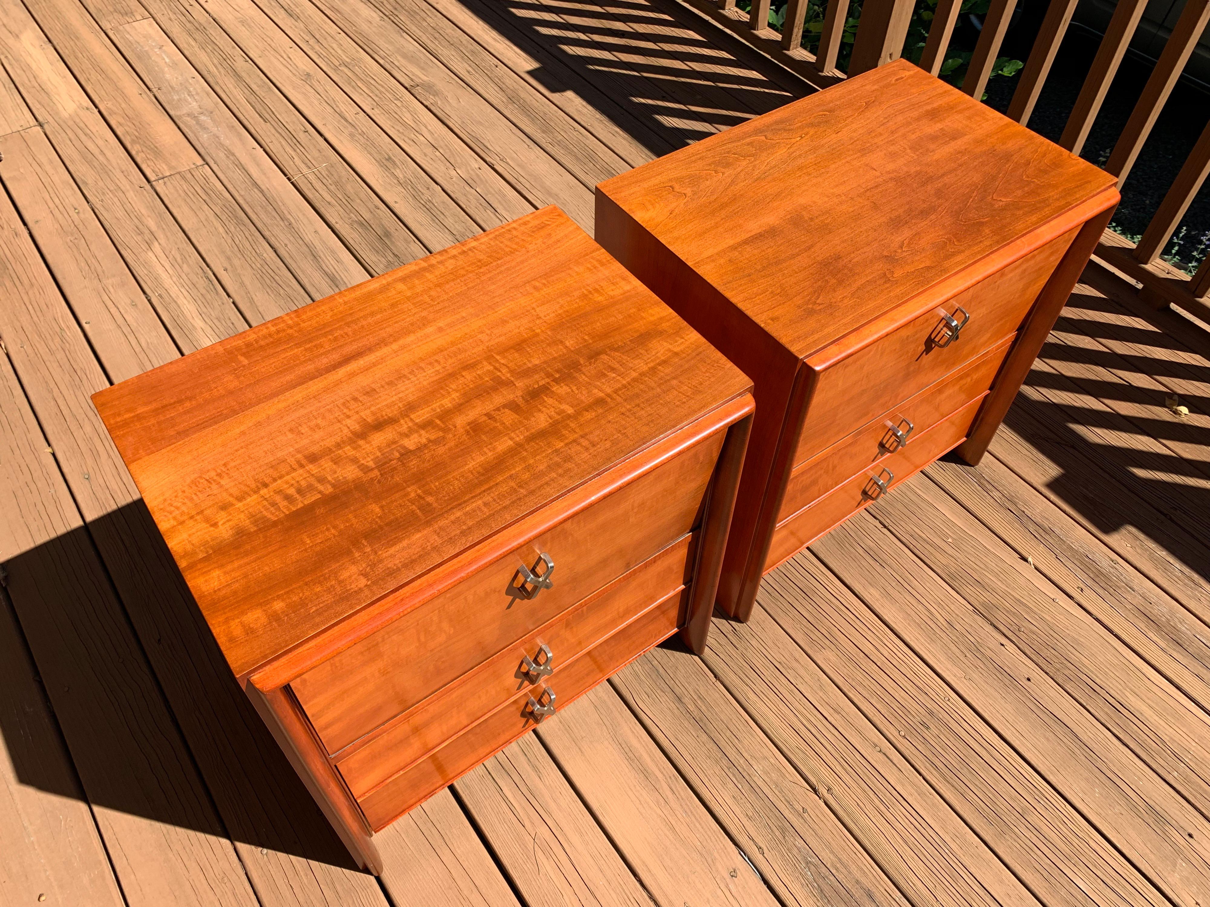 A beautiful pair of cherry wood nightstands designed by Paul Frankl for Johnson Furniture company having nickel X-pulls and signature flip down doors, circa 1955.