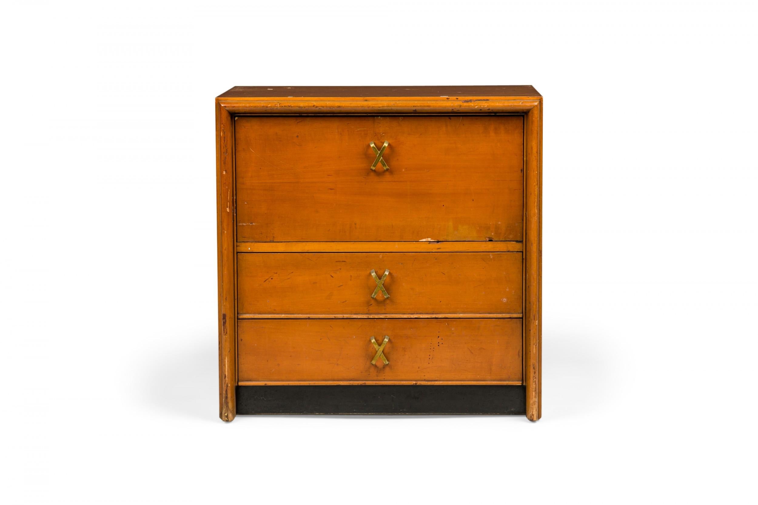 Pair of mid-century wooden bedside table / commodes with an upper cabinet with fold-down drawer above two lower drawers with x-form brass drawer pulls. (Paul Frankl for Johnson Furniture Company)(Priced as Pair).