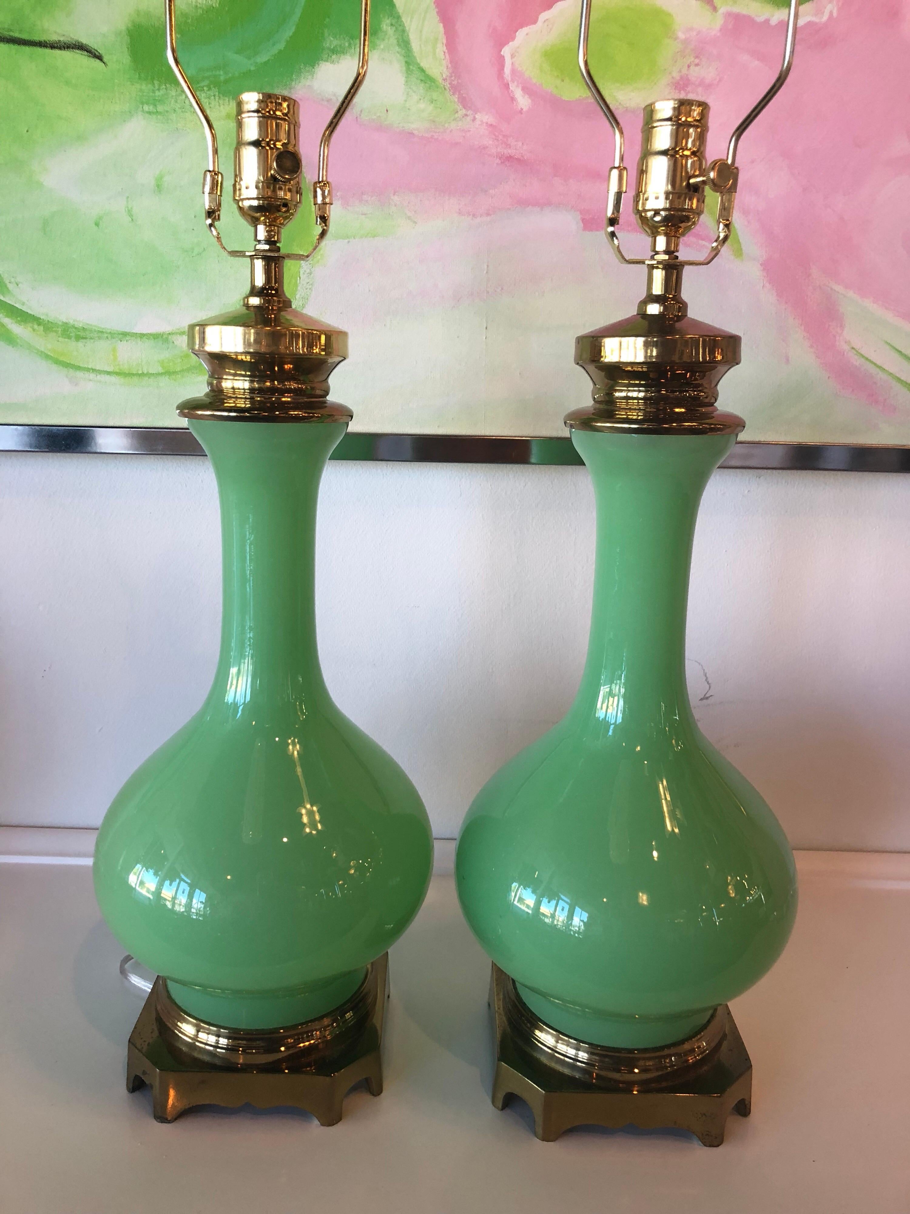 Vintage pair of Paul Hanson Jadeite green glass table lamps. These have all new brass hardware and have been professionally rewired. Includes harp and brass finials. The brass base is original and does have normal age and patina.