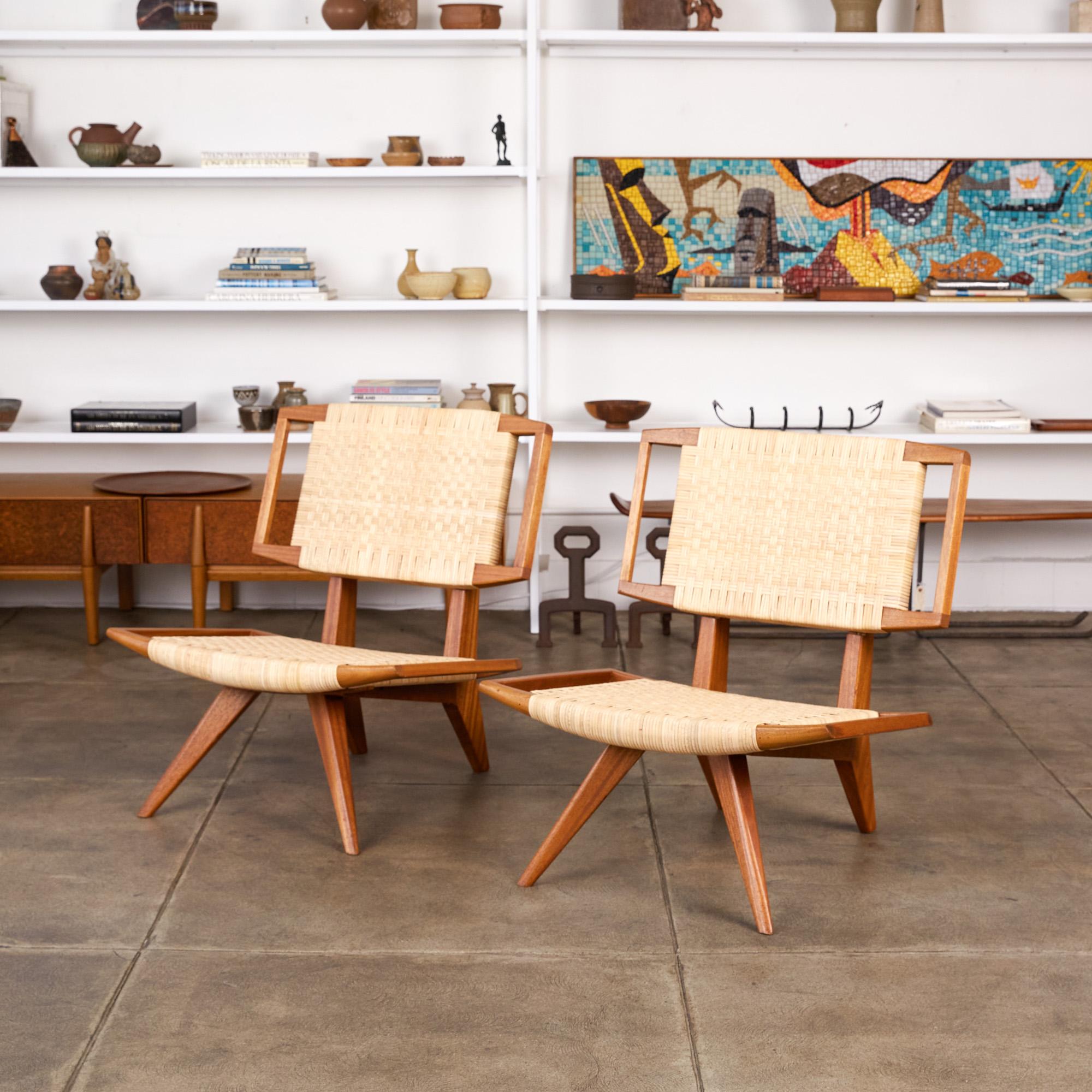A pair of rare, museum grade lounge chairs by Paul Laszlo for Glenn of California, circa 1950s. The chairs feature an oiled mahogany frame with newly woven cane seat and back. The woven seat lays atop the frame that is supported by outwardly pitched