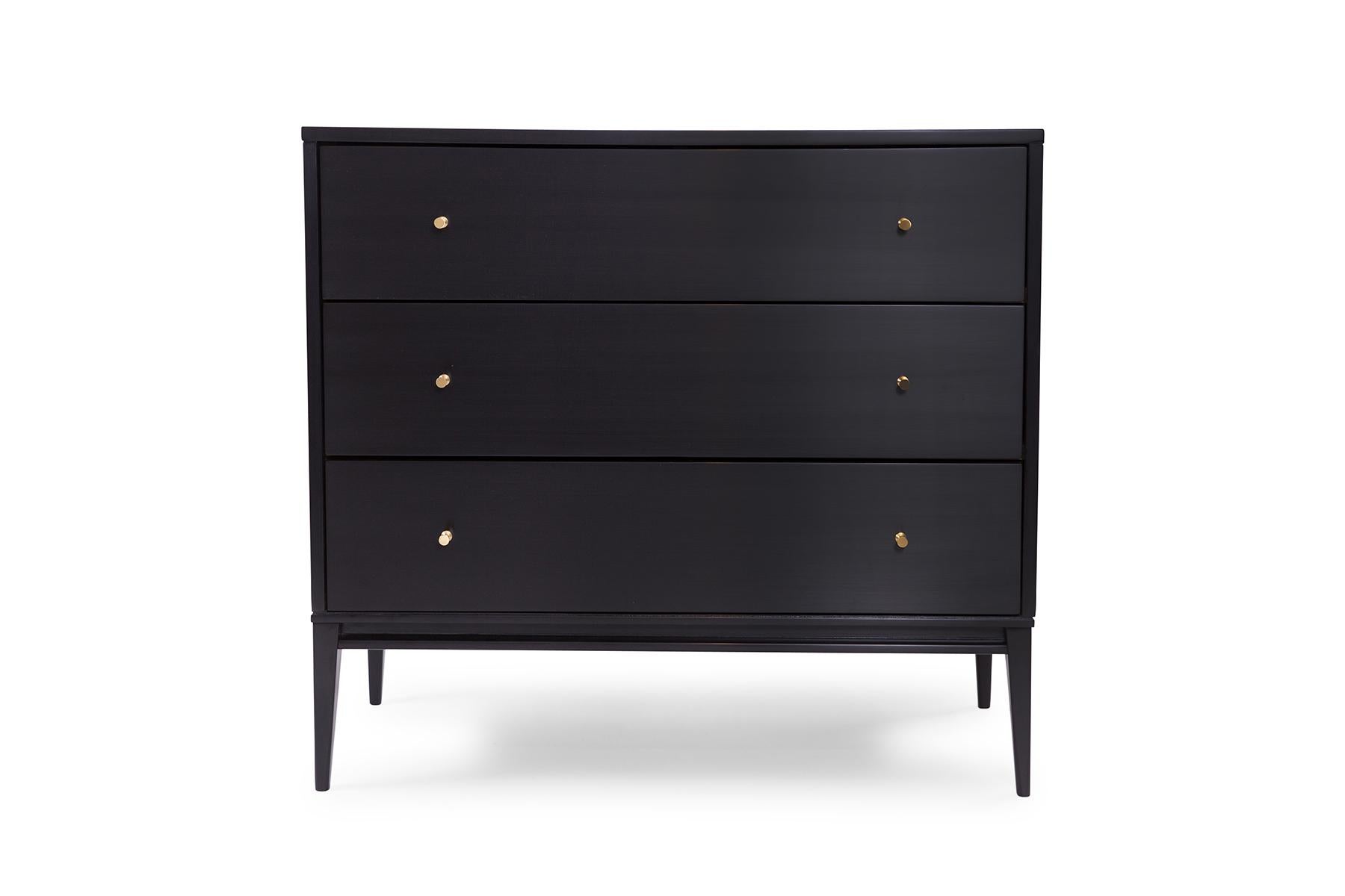 Pair of Paul McCobb three-drawer chests, circa late 1950s. These stunning examples have solid brass hardware, tapered legs and have been newly and impeccably refinished in a hand rubbed black lacquer finish. The hand rubbed finish is the same as