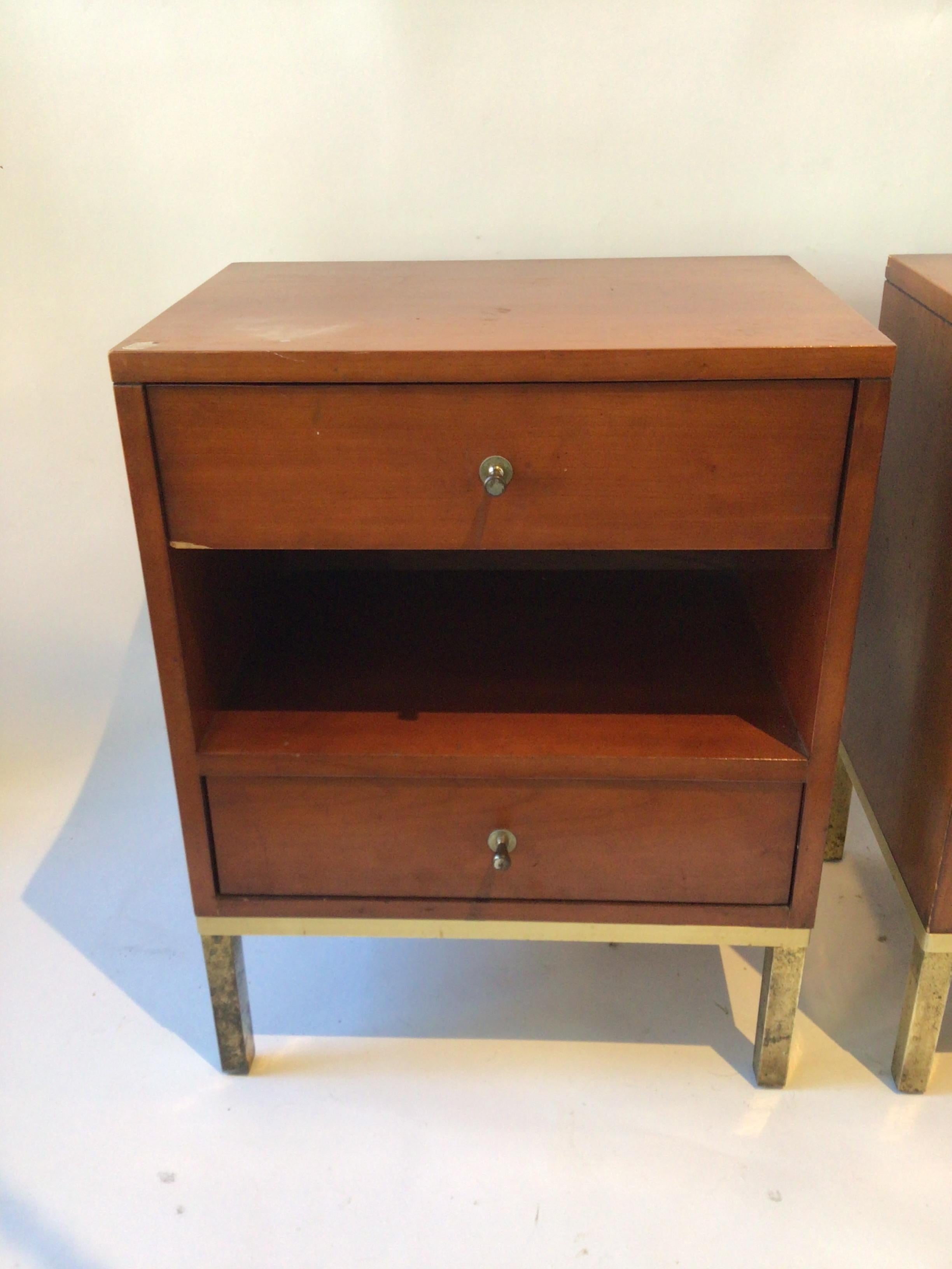 Pair of Paul McCobb end tables. Brass bases. Wood needs refinishing. One hole in back panel. Brass needs refinishing.