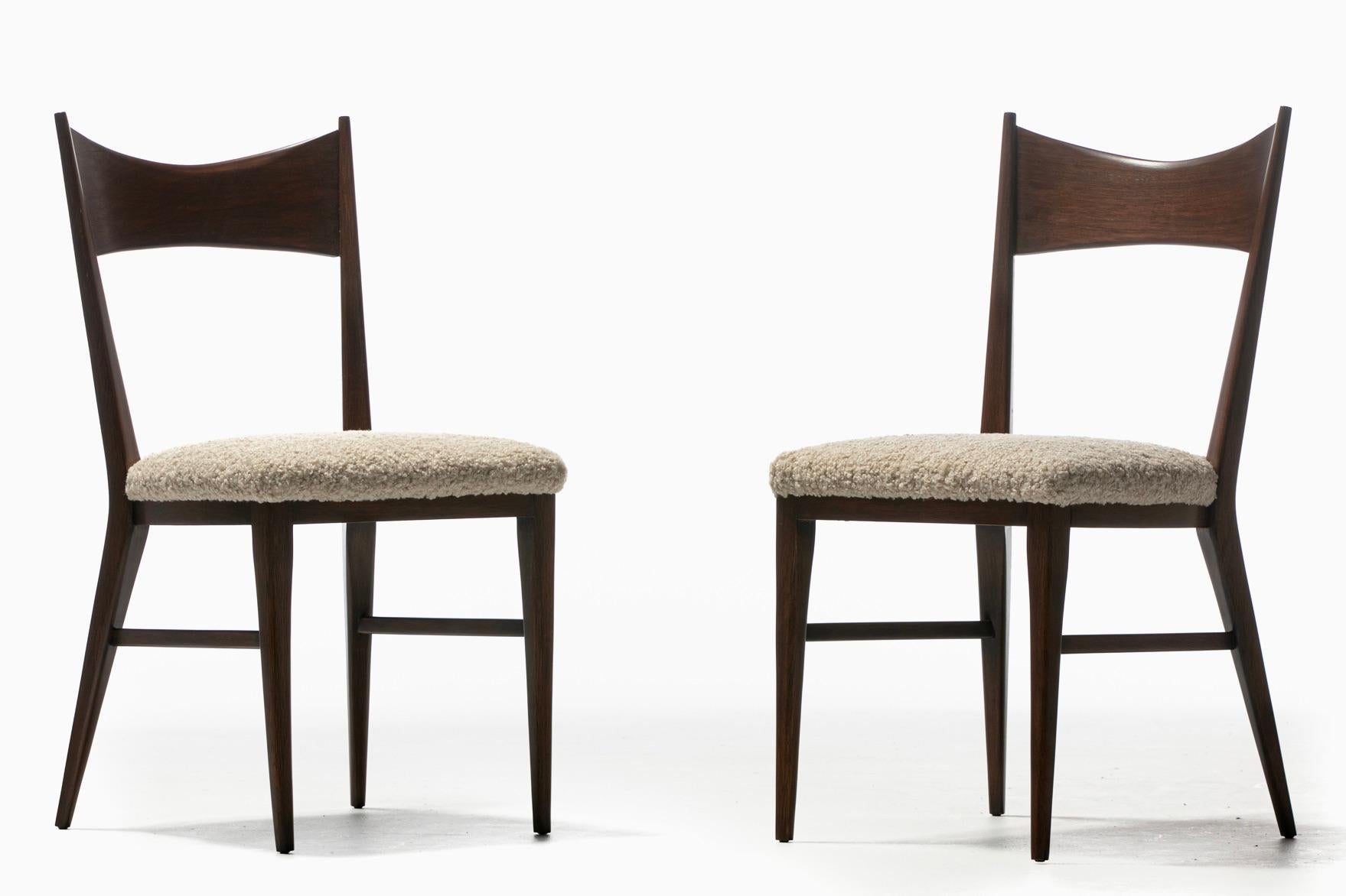 An inspiring pair of fully restored Paul McCobb walnut side chairs with new seat upholstery finished in softly textured ivory white bouclé. Paul McCobb is known for his talented delivery of sexy classic Mid-Century Modern best of the best furniture.