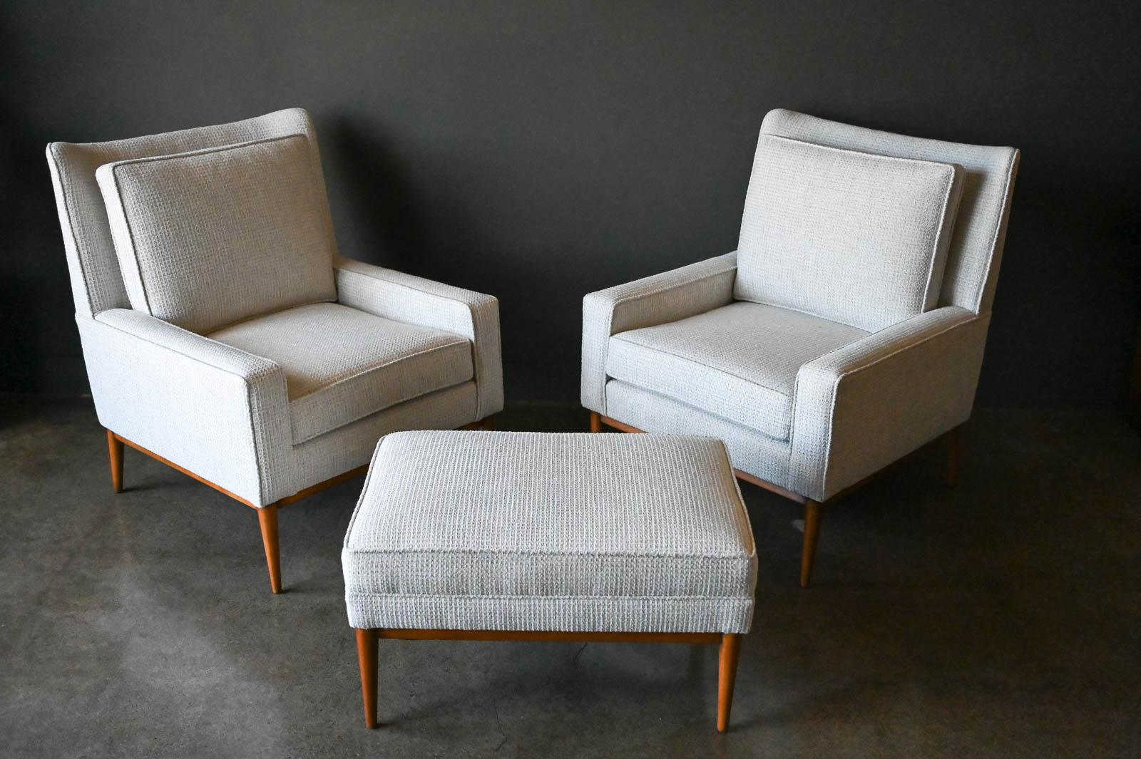 Pair of Paul McCobb Model 302 lounge chairs with ottoman, circa 1955. Professionally restored in excellent condition, these chairs have the matching ottoman redone in beautiful textured neutral tweed with hints of grey and beige. Exceptionally