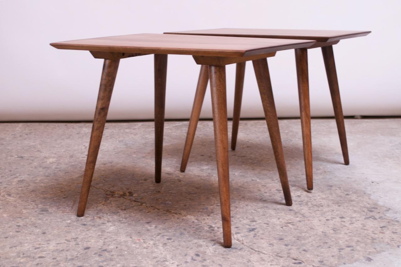 Matched pair of minimal-form stained maple side tables designed in the 1950s by Paul McCobb for Winchendon. Thin, tapered legs add a nice contour to an otherwise modest design. (Legs on one table have been permanently affixed and cannot be removed