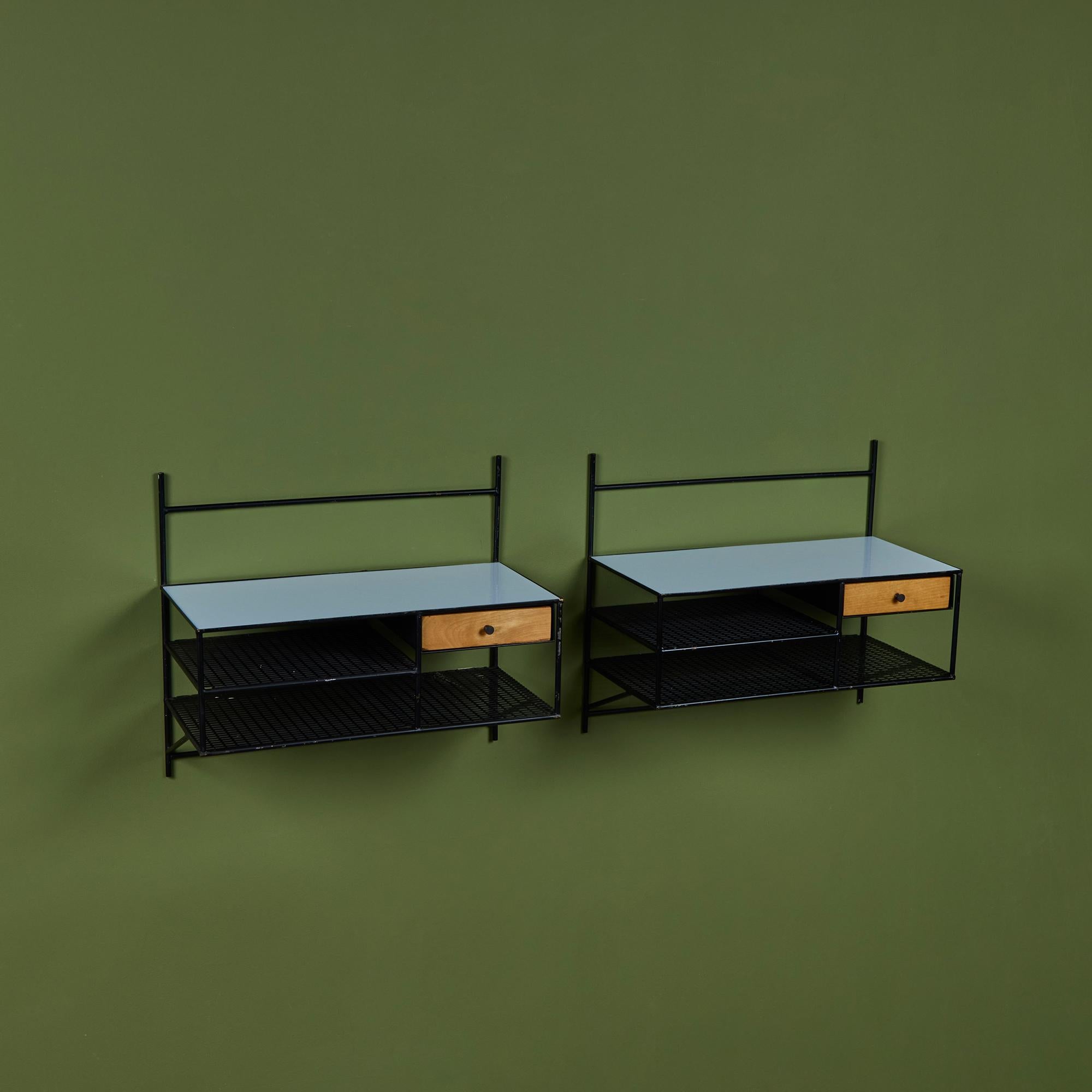 Paire de tables de nuit murales flottantes de Paul McCobb pour Bryces Originals, c.1950. La paire comprend un cadre en fer forgé apparent, un seul tiroir en érable, avec deux étagères en acier perforé et un plateau en verre blanc. Conçu à l'origine