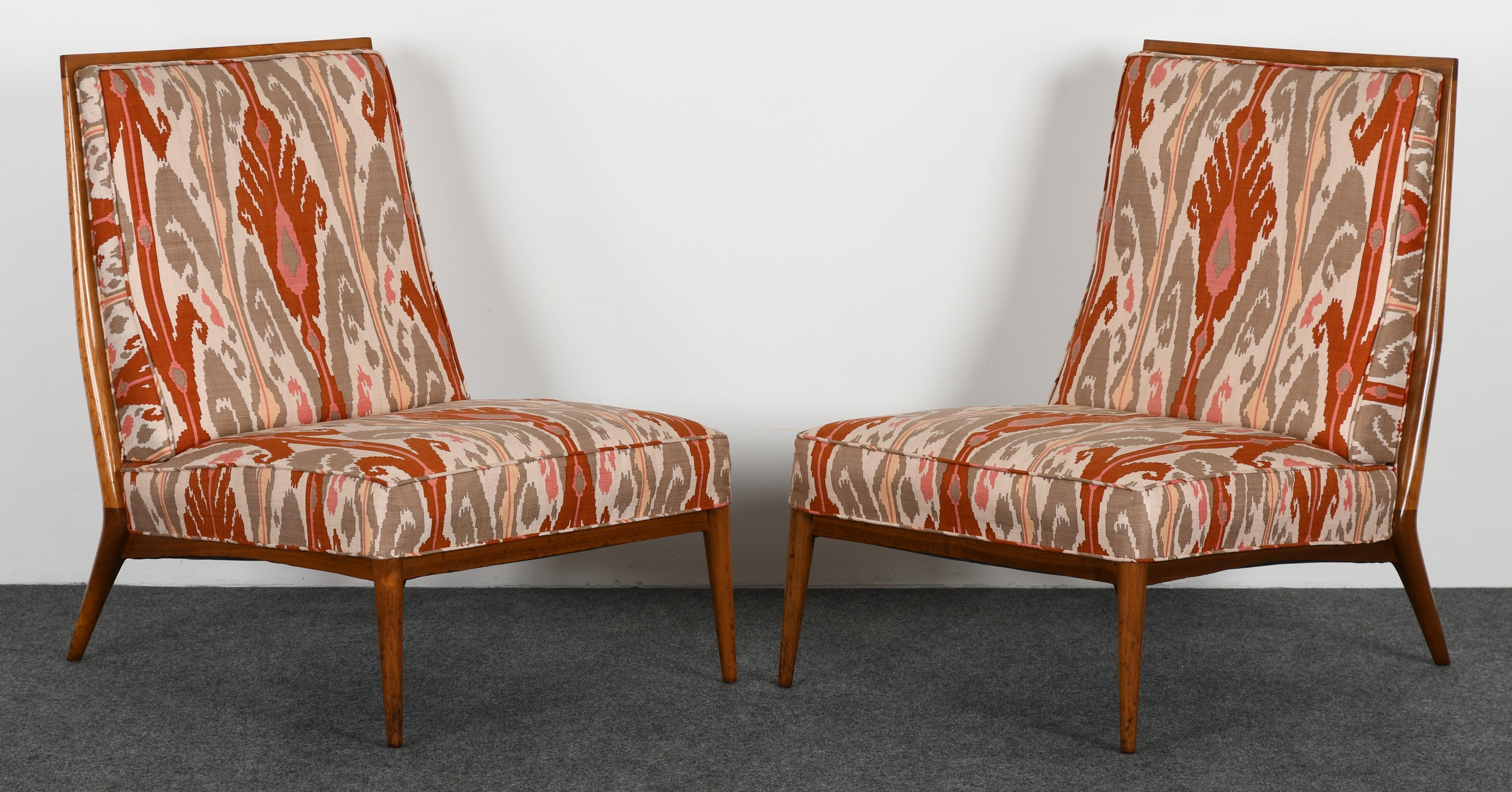 A pair of Paul McCobb walnut slipper chairs, 1960s. The chairs are structurally sound, some scratches and wear to finish, as shown in images. New fabric and refinishing recommended.

Dimensions: 34