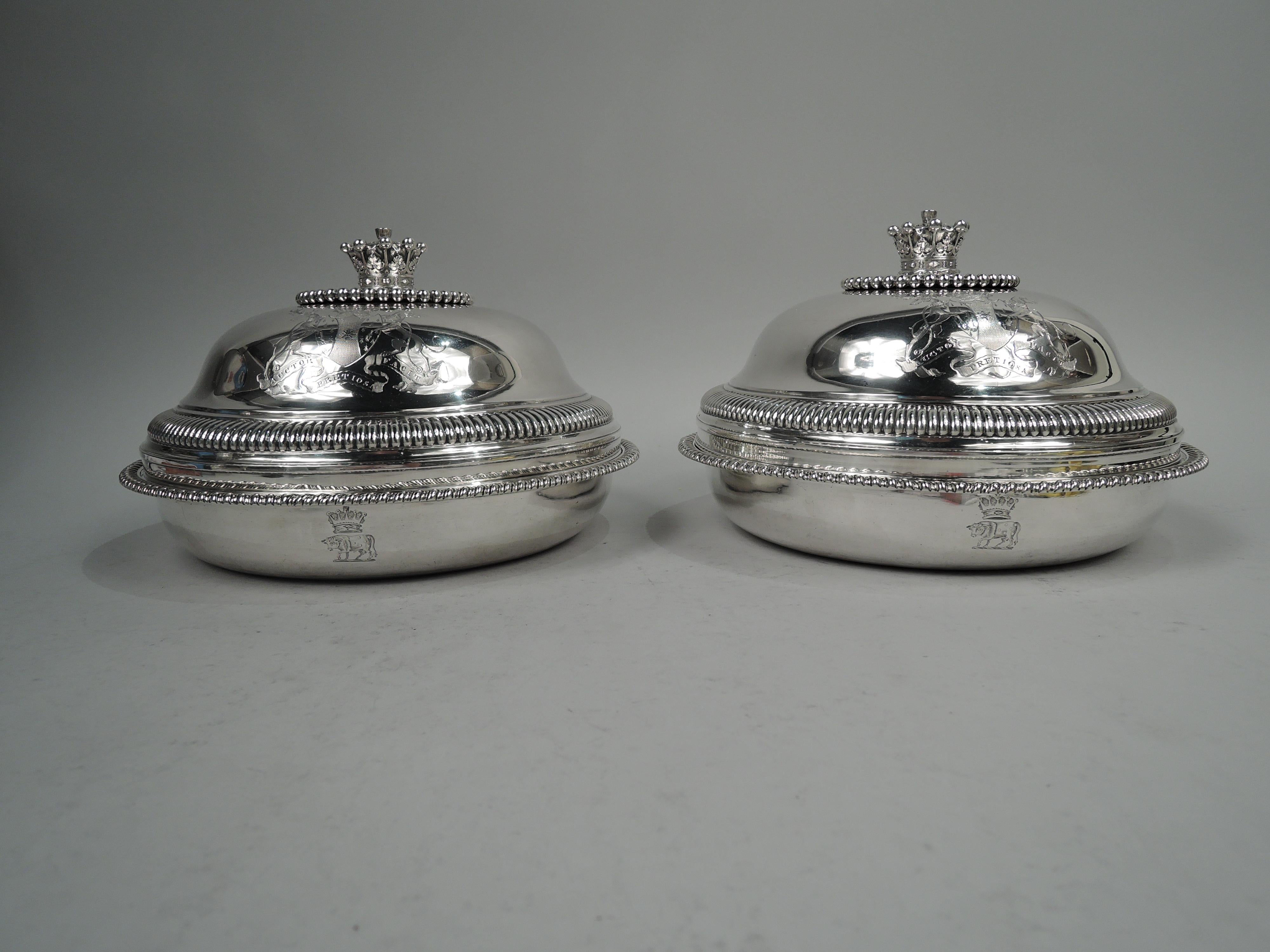 Pair of George III sterling silver covered vegetable dishes. Made by Paul Storr in London in 1805. Each: Tapering bowl with gadrooned rim. Cover domed with lobed shoulder; cast coronet finial mounted to round disc with beaded border. Engraved coat