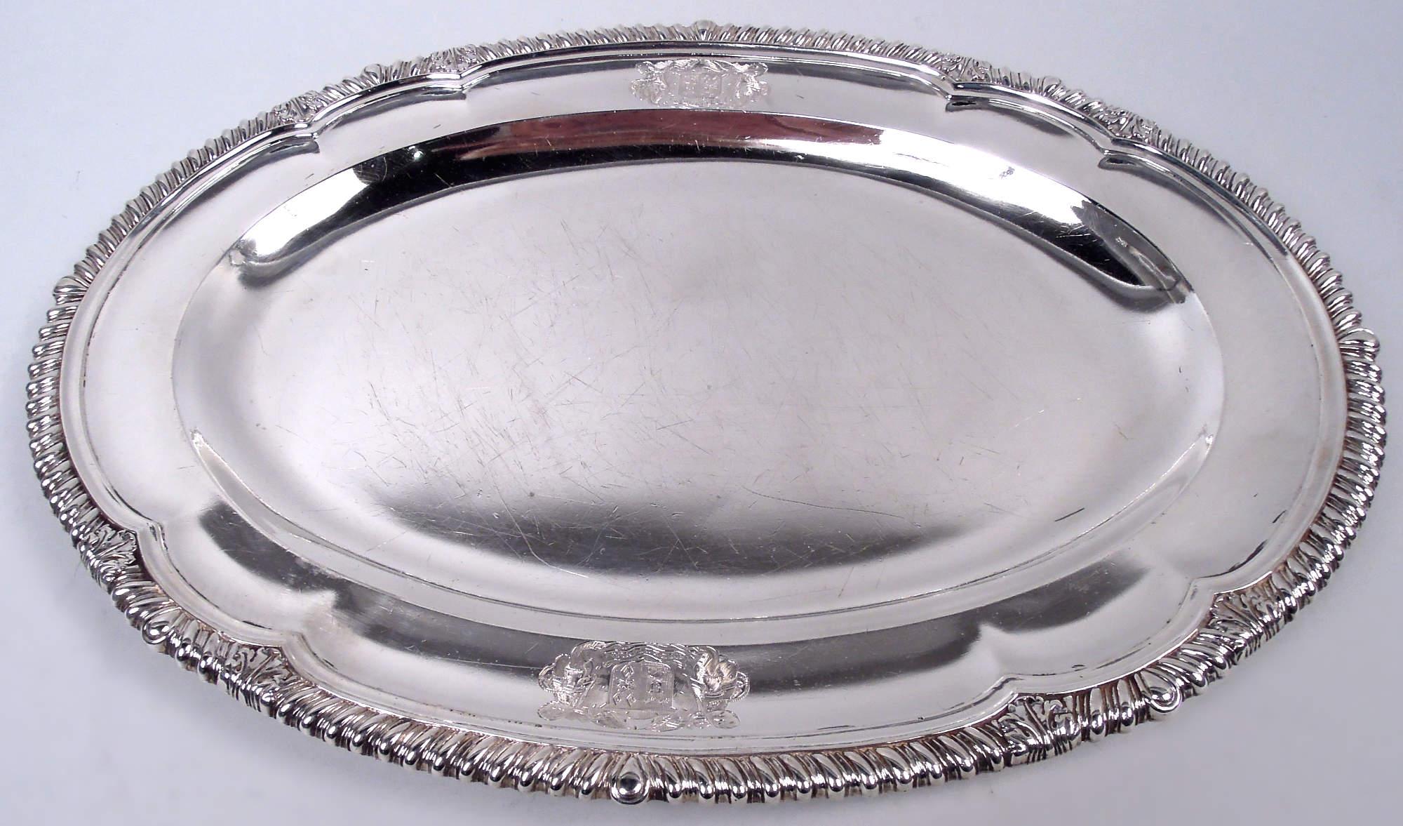 Pair of George III sterling silver trays. Made by Paul Storr in London in 1814. Each: Oval well and serpentine gadrooned rim interspersed with leaves. On shoulder, engraved armorials for Sir Foster Cunliffe, 3rd baronet (1755-1834) and his wife