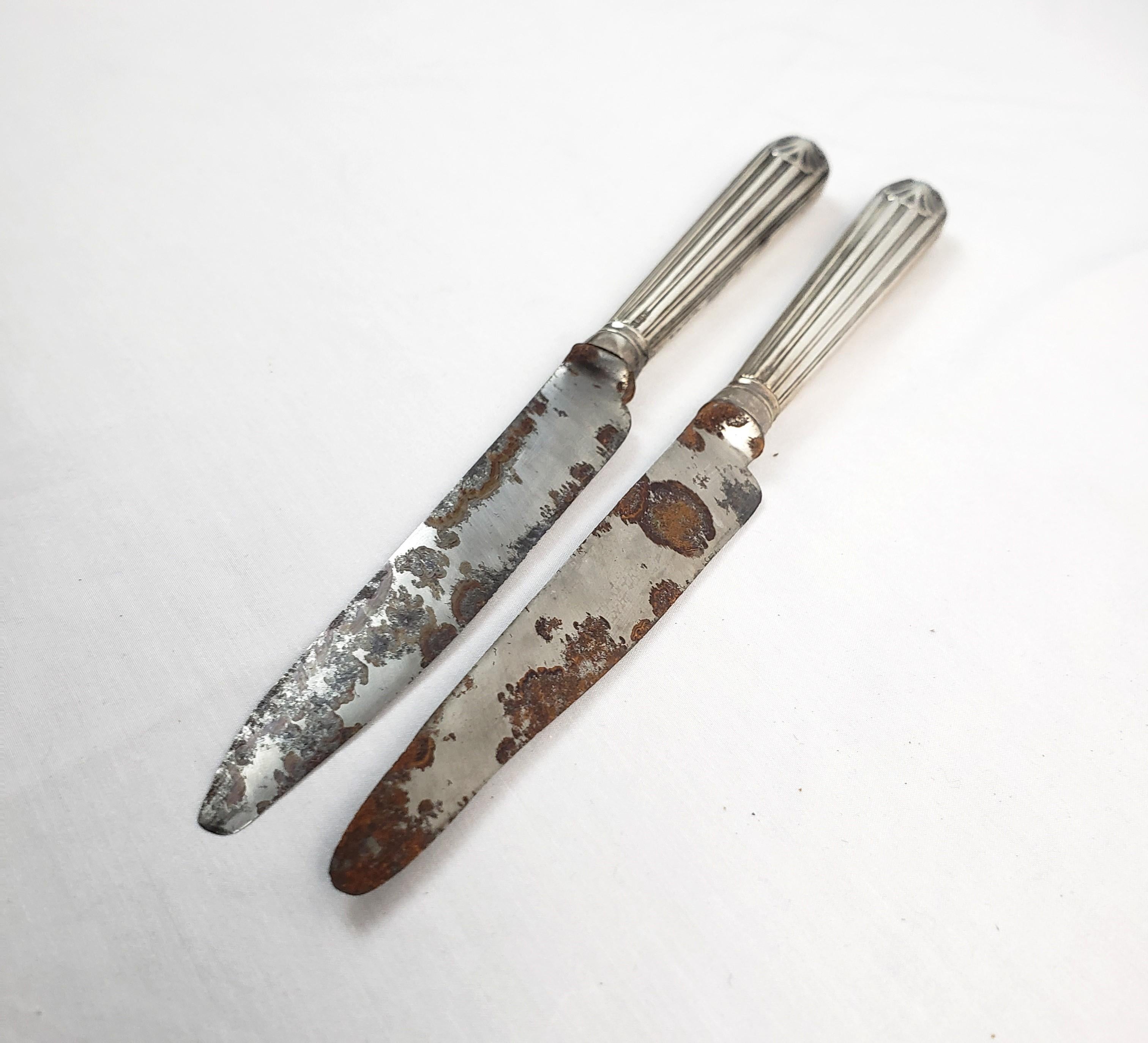 This pair of antique knives were made by the renowned silversmith, Paul Storr of England and date to approximately 1807 and done in the period Georgian style. The handles are done in sterling silver with ribbed sides and scalloped details at the