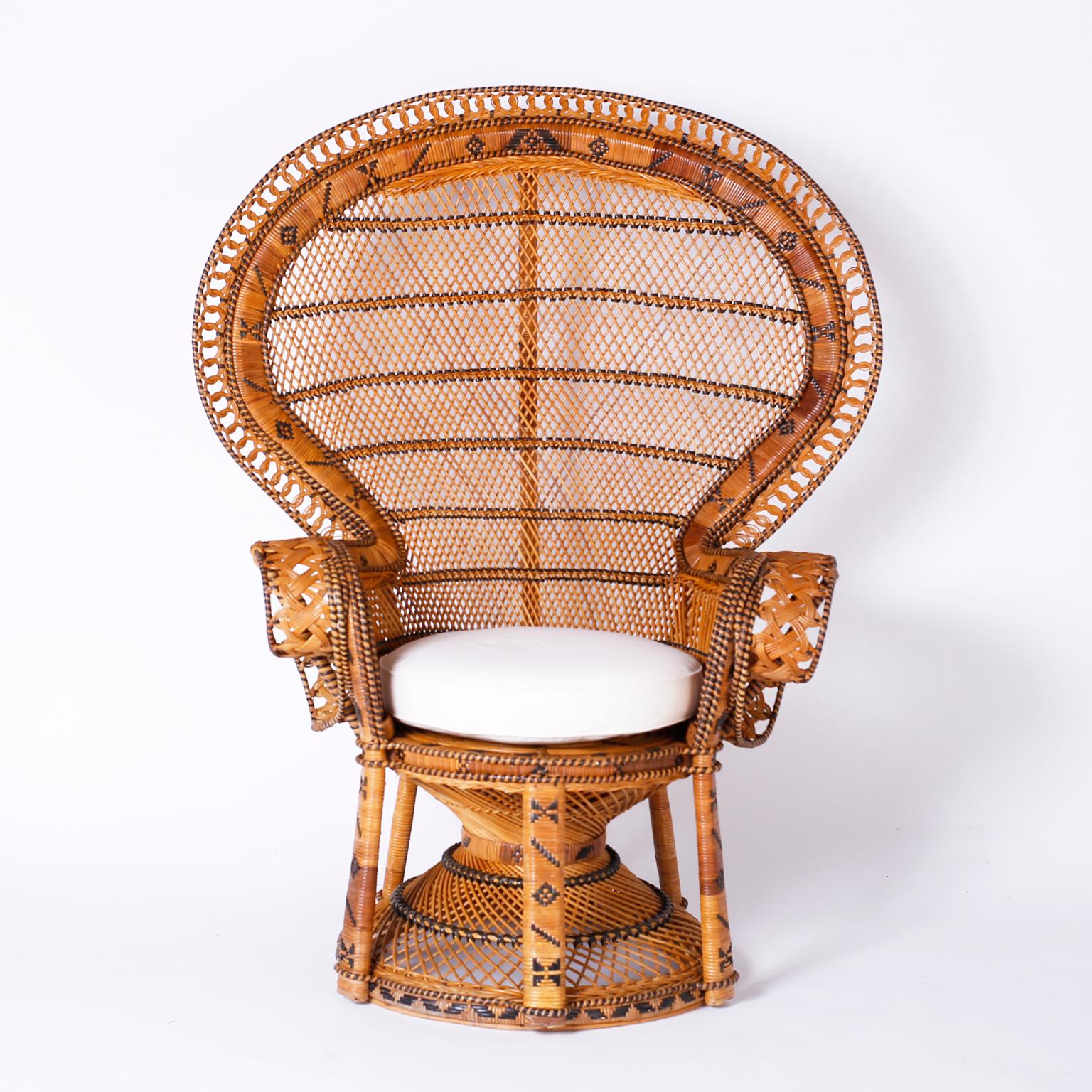 Near pair of peacock chairs with their iconic form crafted in wicker and reed with woven geometric designs and a matching round table. Best of the genre. 

Table measures- H: 21 DM: 26.5