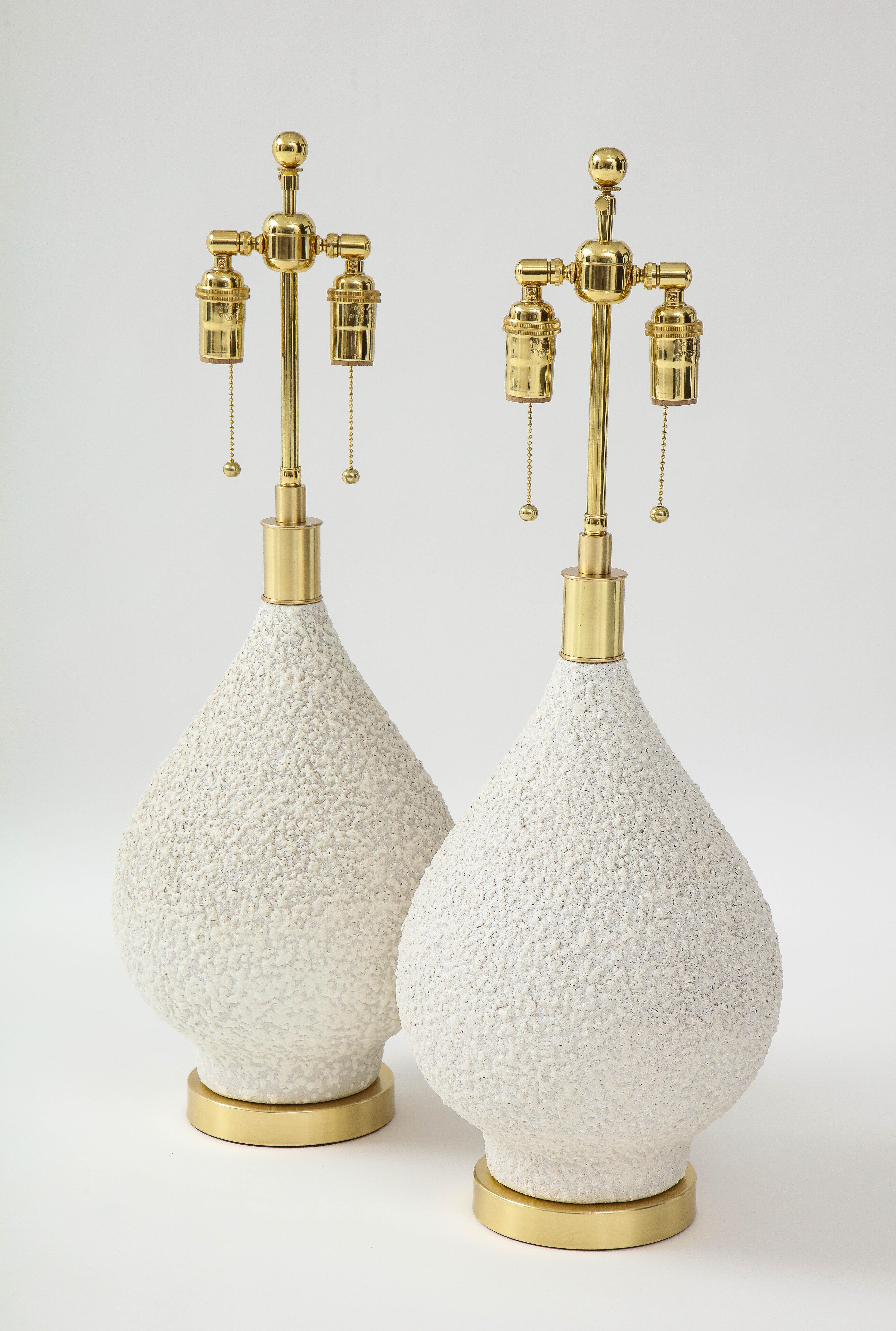 Pair of 1970's Pear shaped ceramic lamps with a Popcorn textured finish.
The lamps sit on brass bases and are Newly rewired with adjustable
polished Brass double clusters.
The height to the top of the ceramic is 15