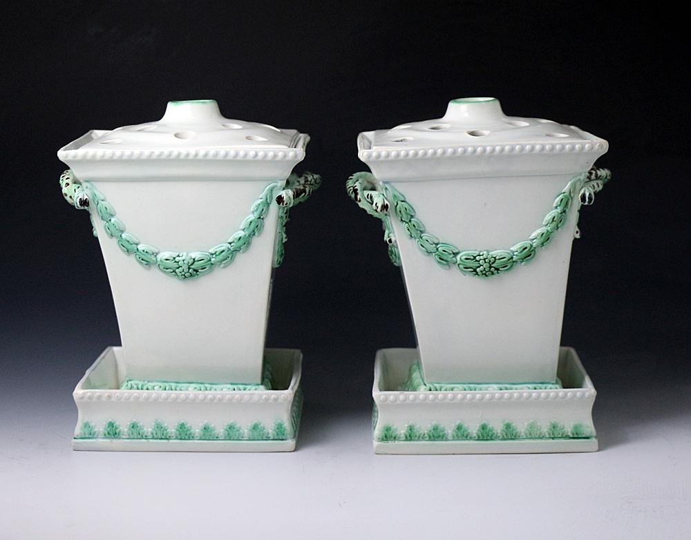 Dated: 1795-1810 Hanley Staffordshire, England

A rare pair of pearlware pottery fern pots or flower vases complete with stands and covers. The pots have green acanthus leaf swags and borders, and the handles made in the form of serpents, the