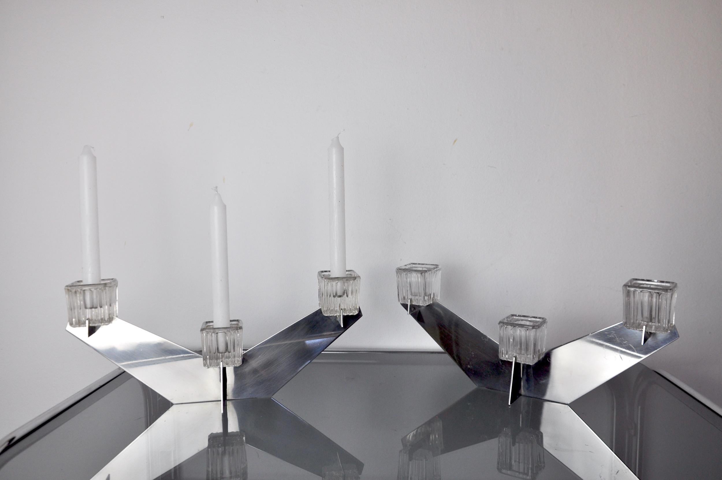 Paire de bougeoirs en verre conçus et produits par Peill et Putzler en Allemagne dans les années 1970. Lot de deux bougeoirs géométriques en métal chromé et verre transparent pouvant accueillir 3 bougies. De beaux objets décoratifs qui apporteront