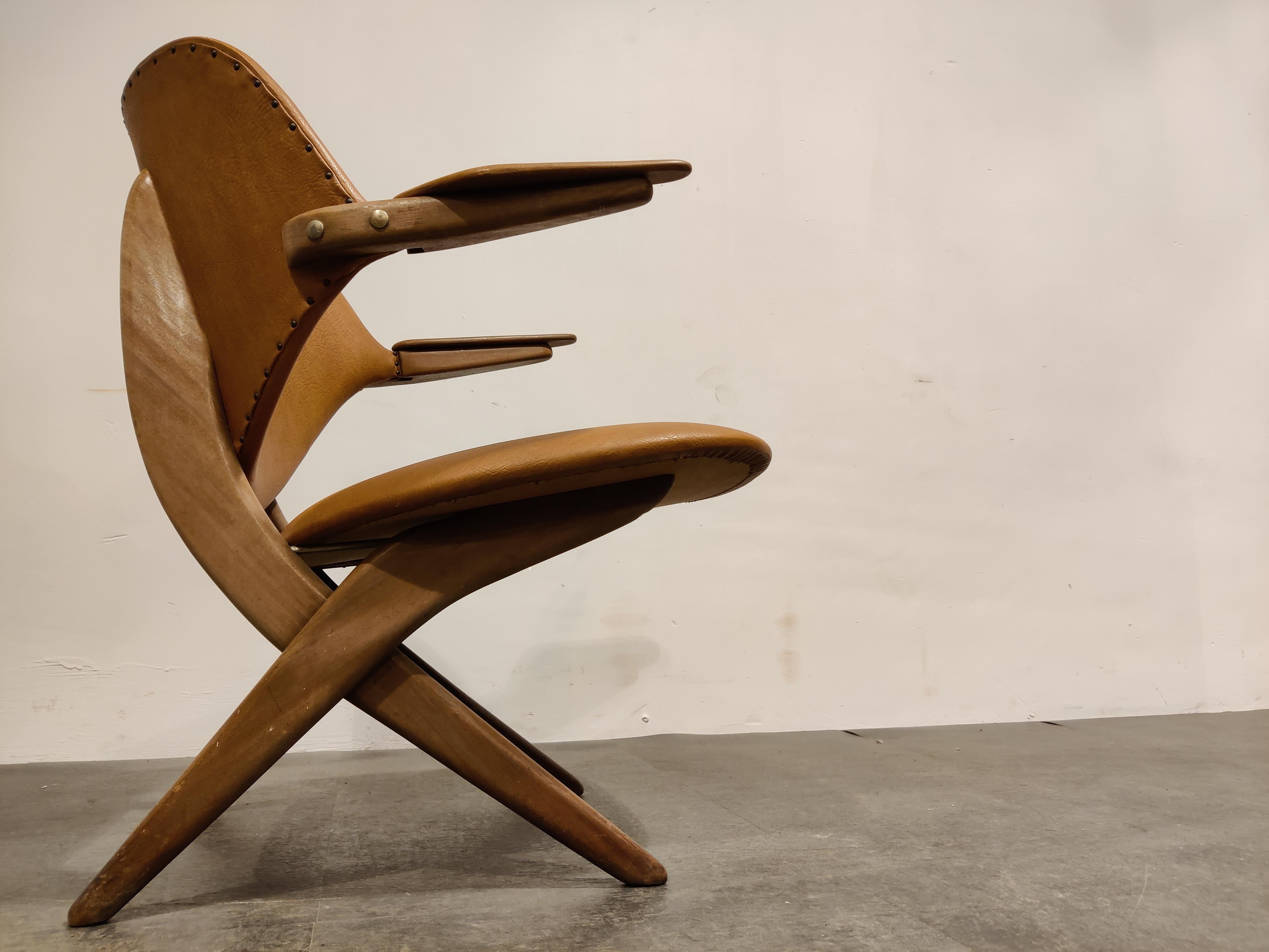 Pair of tan leather and teak armchairs model 'Pelican' designed by Mid century designer Louis Van Teeffelen for Wébé meubelen.

Van Teeffelen is one of our personal favorites because of his beautiful organic designs which translate into elegant