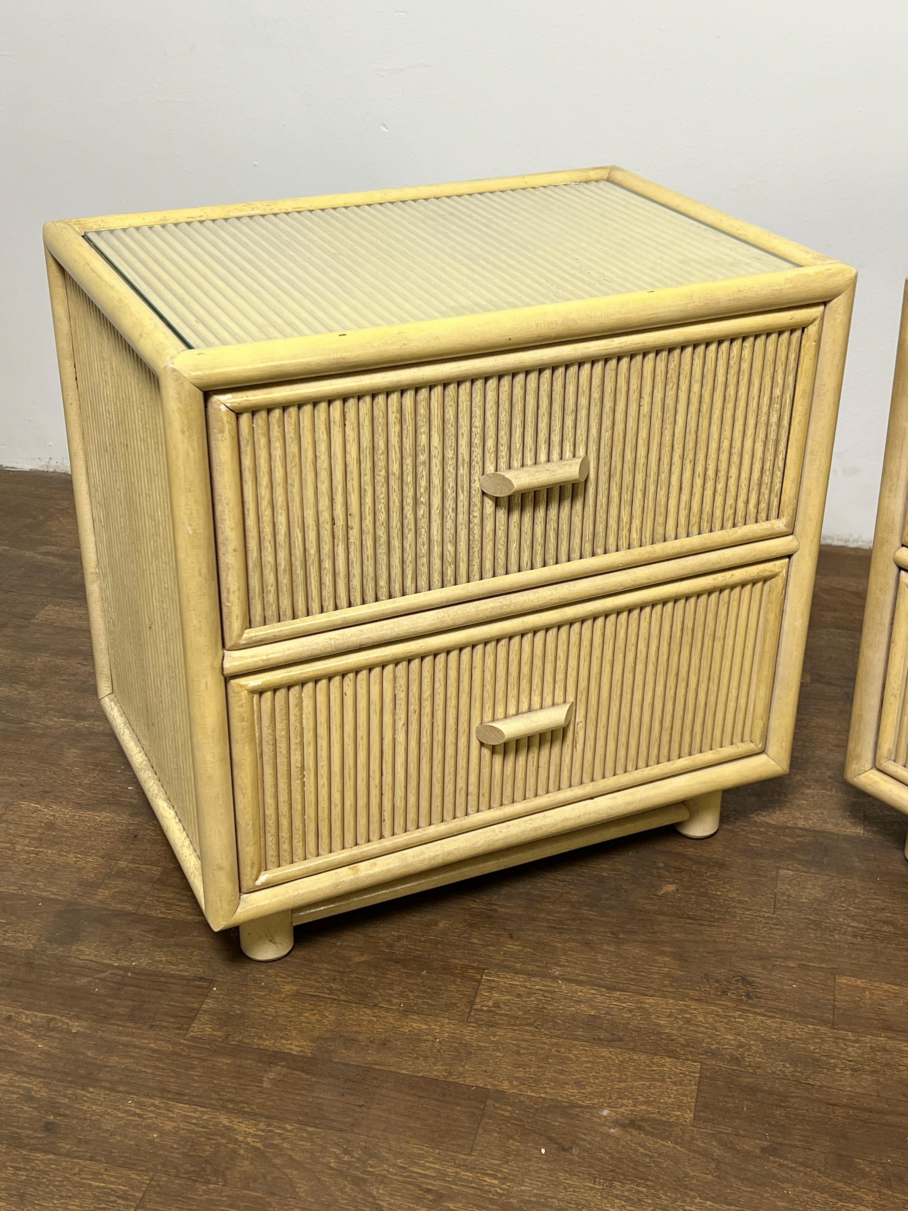 A pair of pencil reed nightstands of two drawers, circa 1970s, made in Taiwan. Can be used with or without the accompanying glass top inserts.

See our separate listing for a matching high boy dresser.