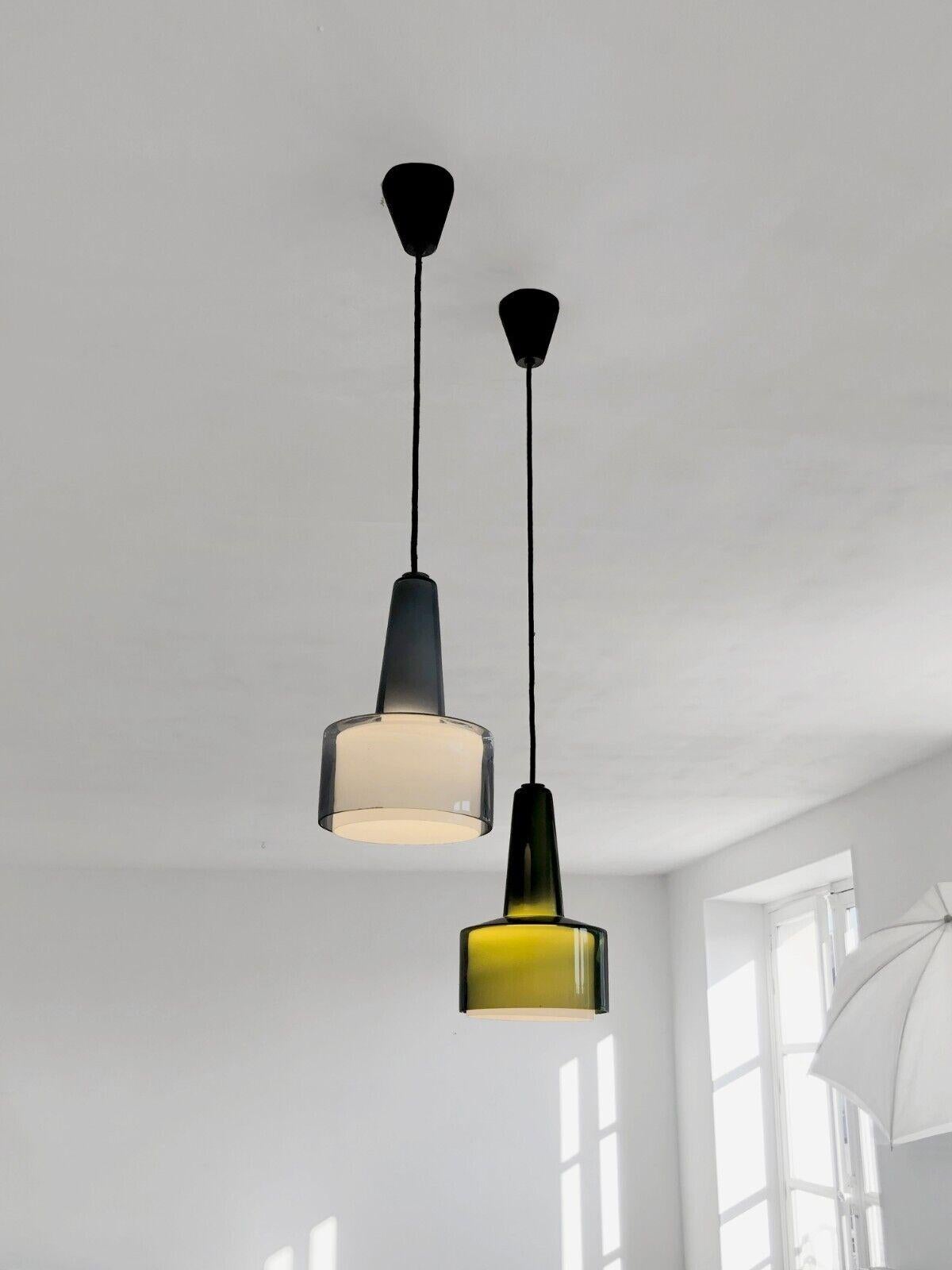 An elegant pair of pendant lights, Modernist, Dansk, Scandinavian, Forme-Libre, each luminaire consisting of 2 suspended glass elements nested one inside the other, exterior element in thick colored glass, interior element in diffusing white opaline