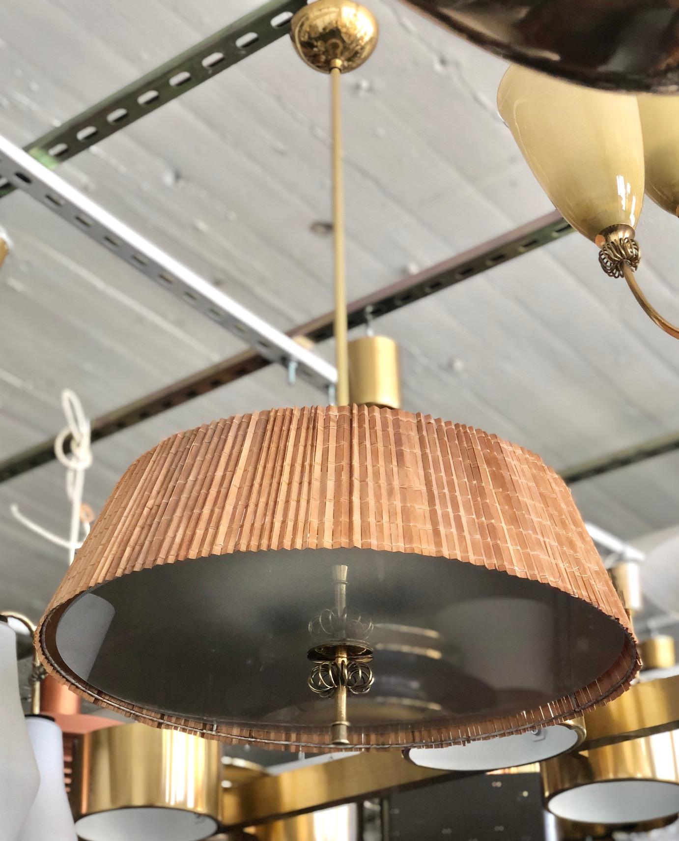 A pair of custom order wood stripes and brass ceiling lights with long stems designed by Paavo Tynell for the interior of Hok Elanto in Helsinki, from the 30's/40's. Overall drop can be adjusted. Rewiring available upon request. Can be sold