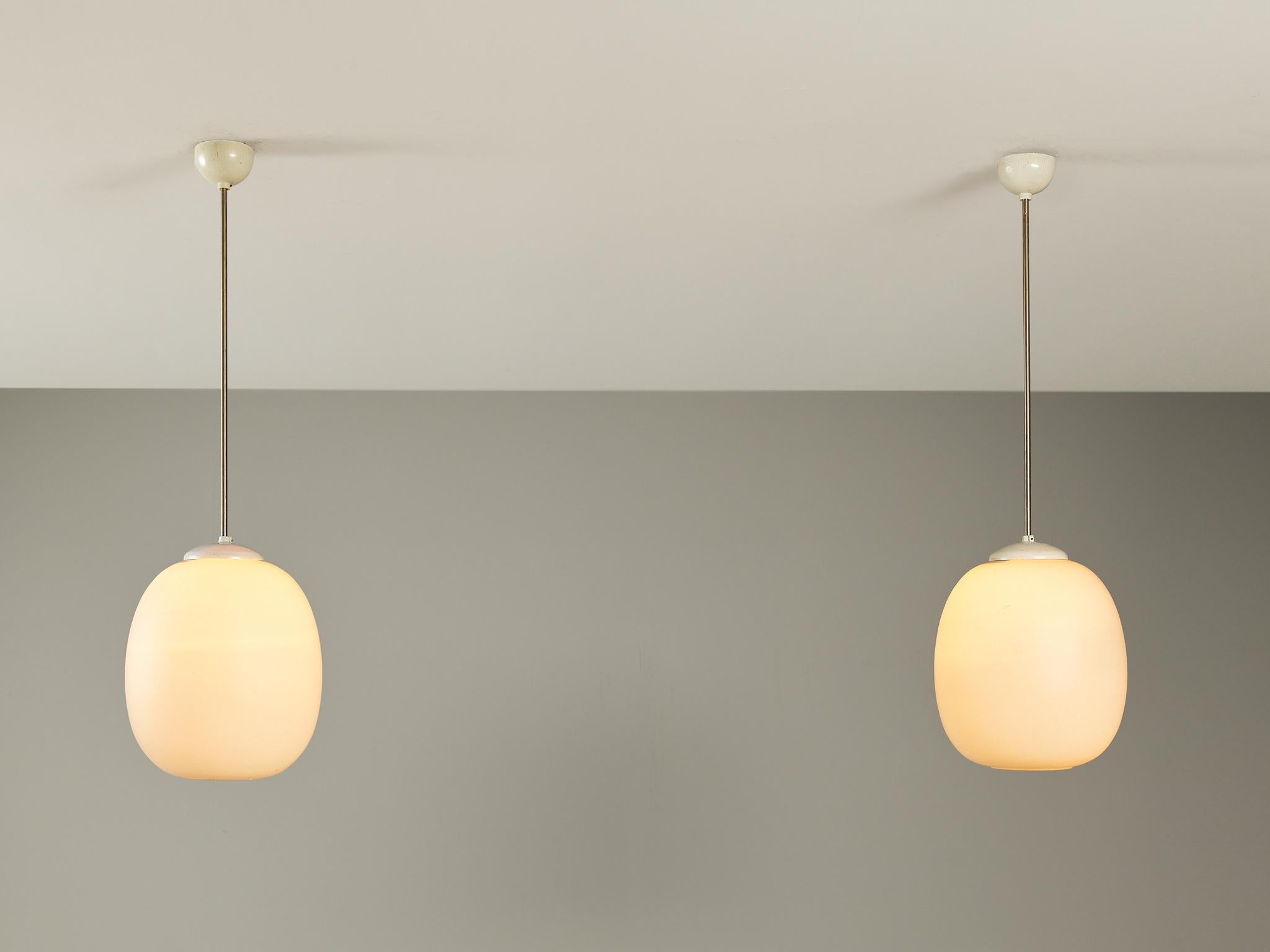 Pair of pendants, opaline glass, coated aluminum, metal, Europe, 1960s 

Clean and simple pendant lamps with opaline glass sphere. The lamps can be hung above a dining table as a set or in an entranceway in order to make an impression, or serve as a