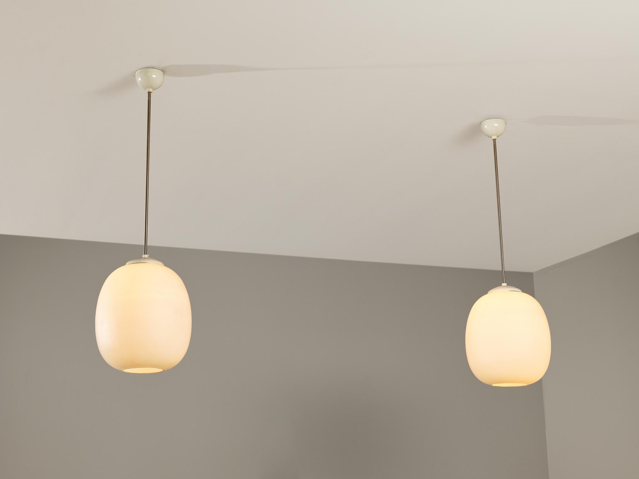 Pair of pendants, opaline glass, coated aluminum, metal, Europe, 1960s 

Clean and simple pendant lamps with opaline glass sphere. The lamps can be hung above a dining table as a set or in an entranceway in order to make an impression, or serve as a