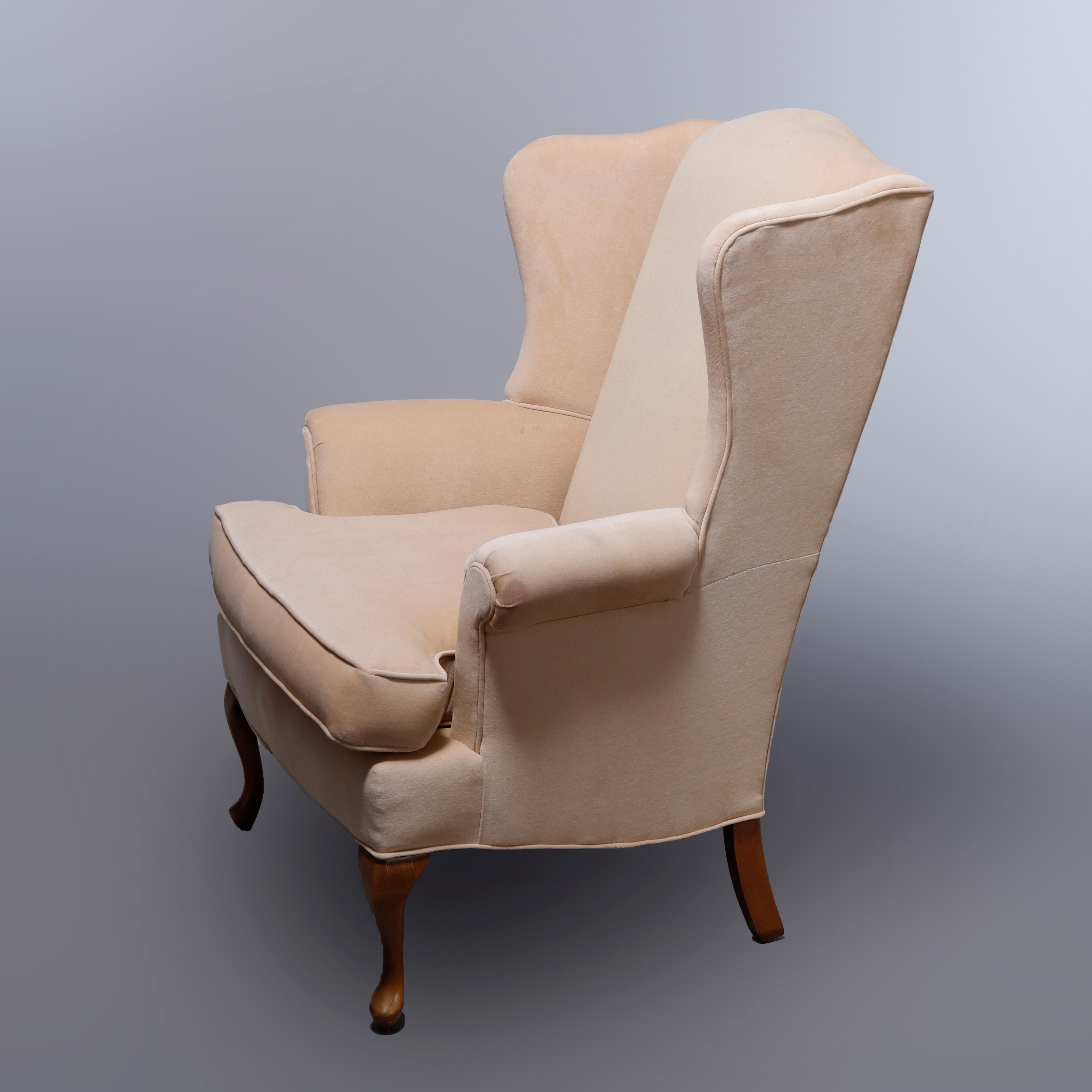A pair of Queen Anne style fireside wingback chairs by Pennsylvania House offer shaped back and scroll arms raised on mahogany cabriole legs, label as photographed, 20th century.

Measures: 42