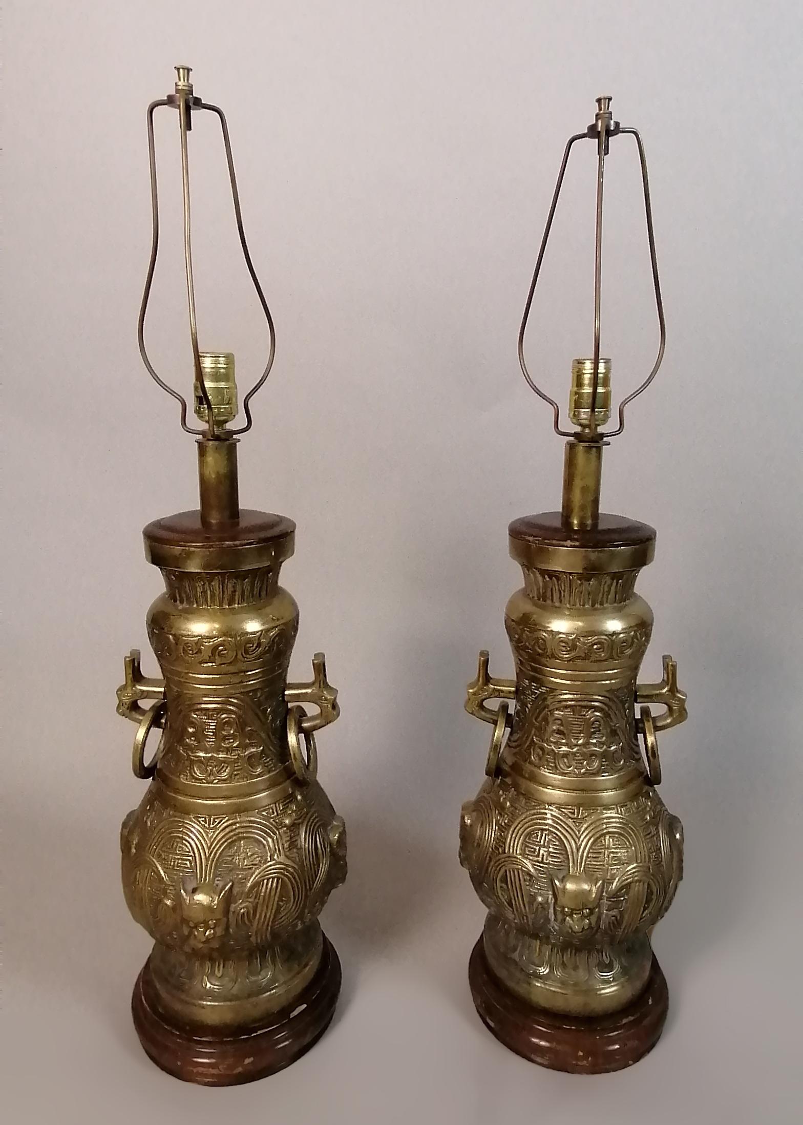Pair of 1960's Mexican bronze table lamps by Pepe Mendoza. The chinoise design shows an Oriental jar with geometric and fantastic elements. Set over wood bases. No apparent marks.