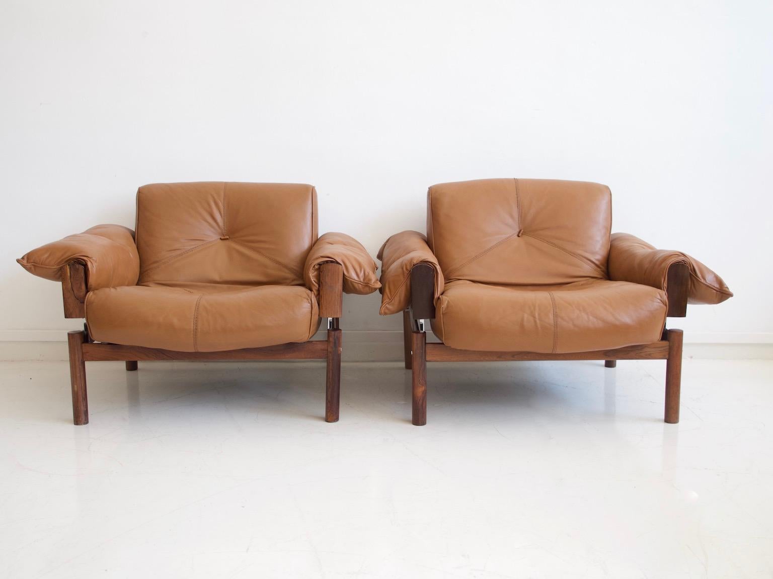 Pair of lounge chairs designed by Percival Lafer and manufactured by MP Lafer in Brazil in the 1970s. Frame in hardwood with leather upholstered seats resting on metal rods.