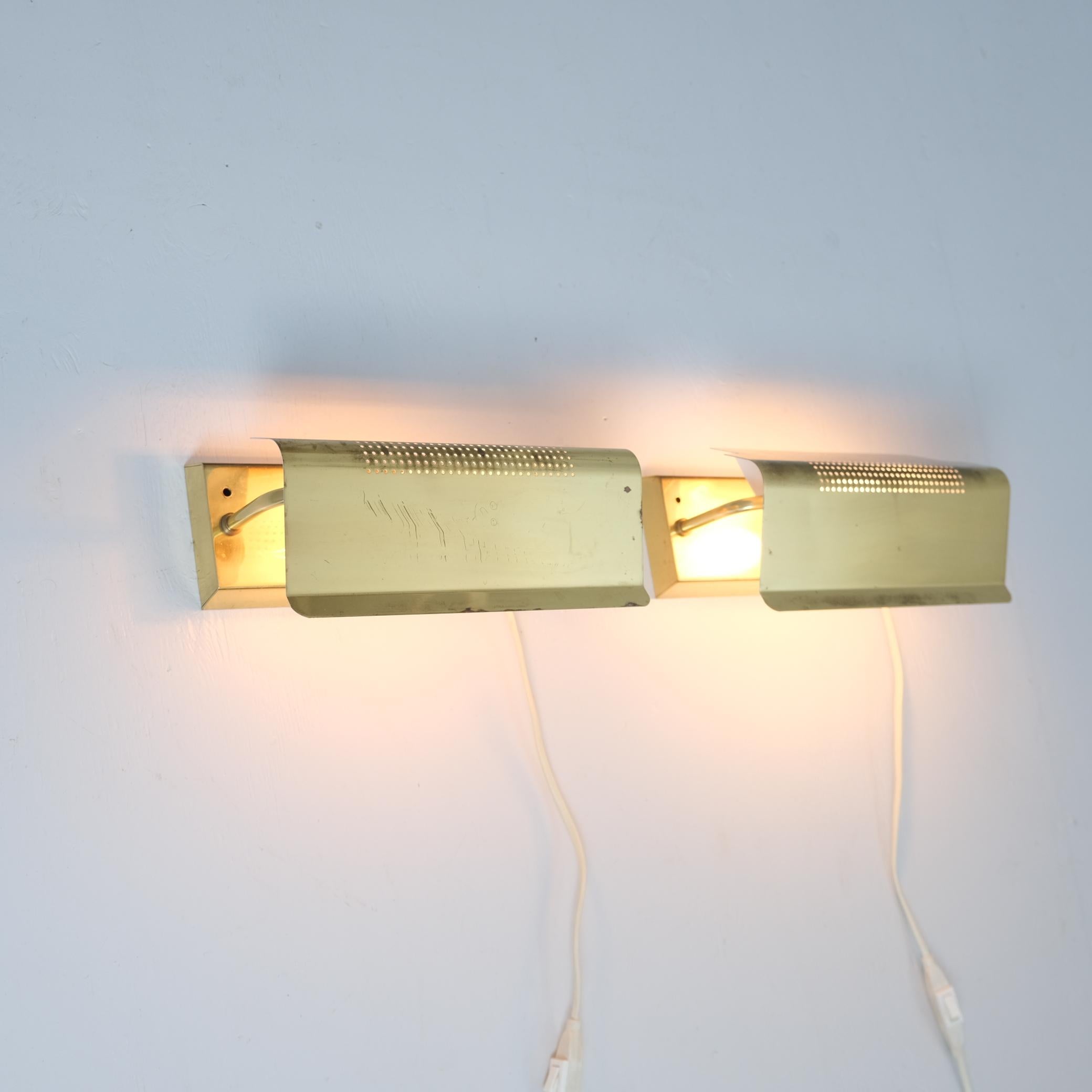 Ein charmantes Paar Wandlampen aus der Mitte des Jahrhunderts vom schwedischen Beleuchtungshersteller NAFA (Nybro Armaturfabrik), um 1970. Mit ihren perforierten Metallschirmen können diese vielseitigen Lampen so eingestellt werden, dass sie das