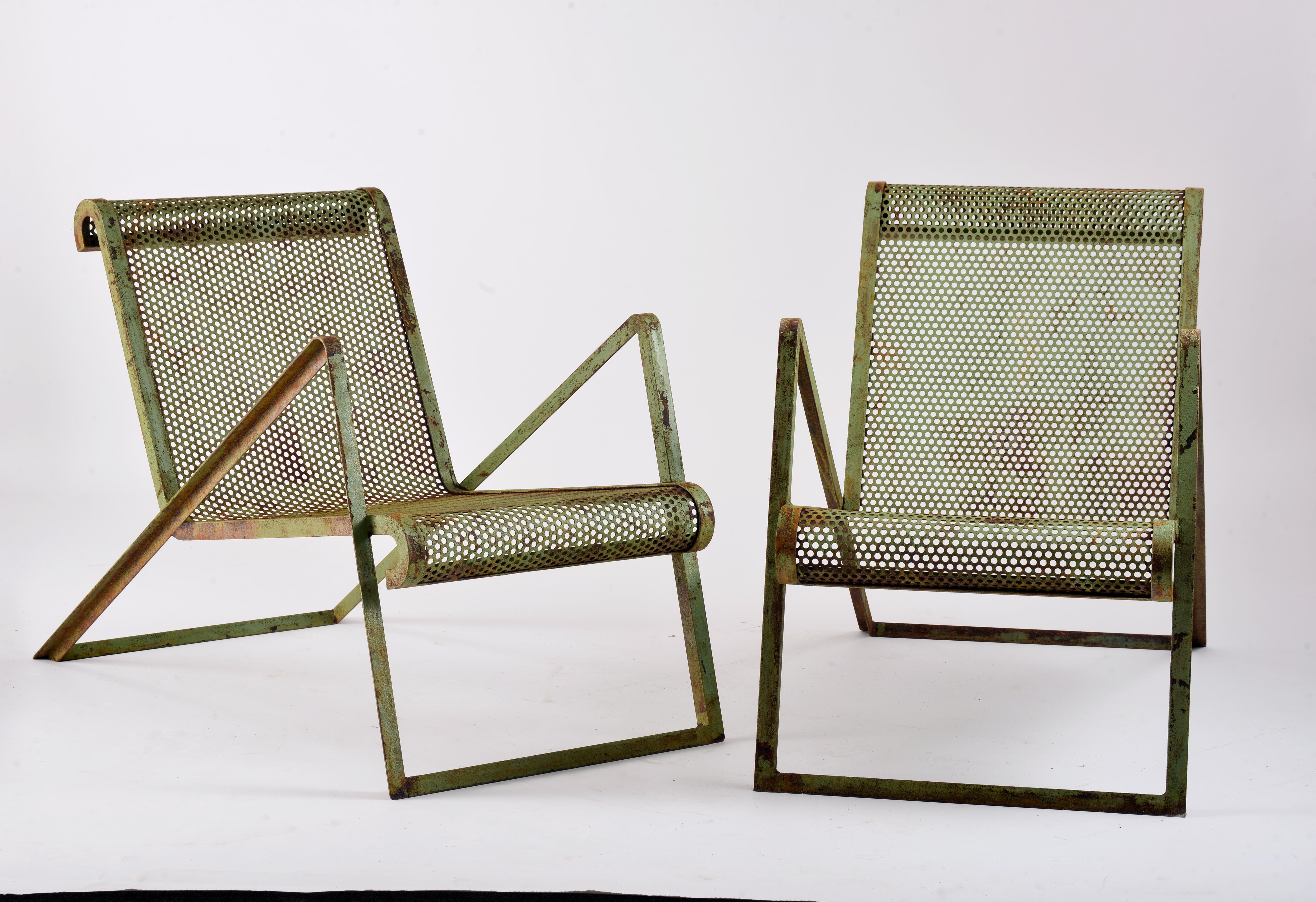 Pair of armchairs in perforated and painted metal in the style of Jean Royère. These are later creations from the end of the 20th century, inspired by the model created in 1937 by Jean Royère for the Exposition Internationale des Arts et Techniques