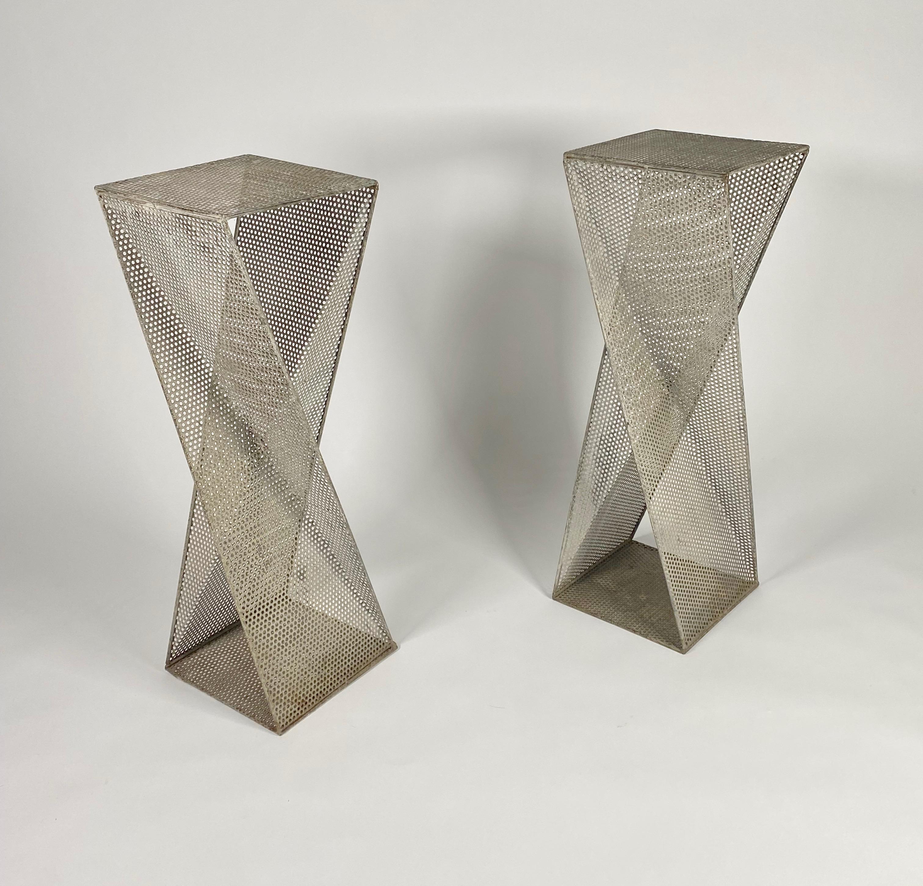 Pair of perforated metal pedestals in the style of Mathieu Mategot, designer unknown. Geometric origami folded forms with a interesting architectural design to them that creates light and shadow patterns in the surrounding environment. They have a