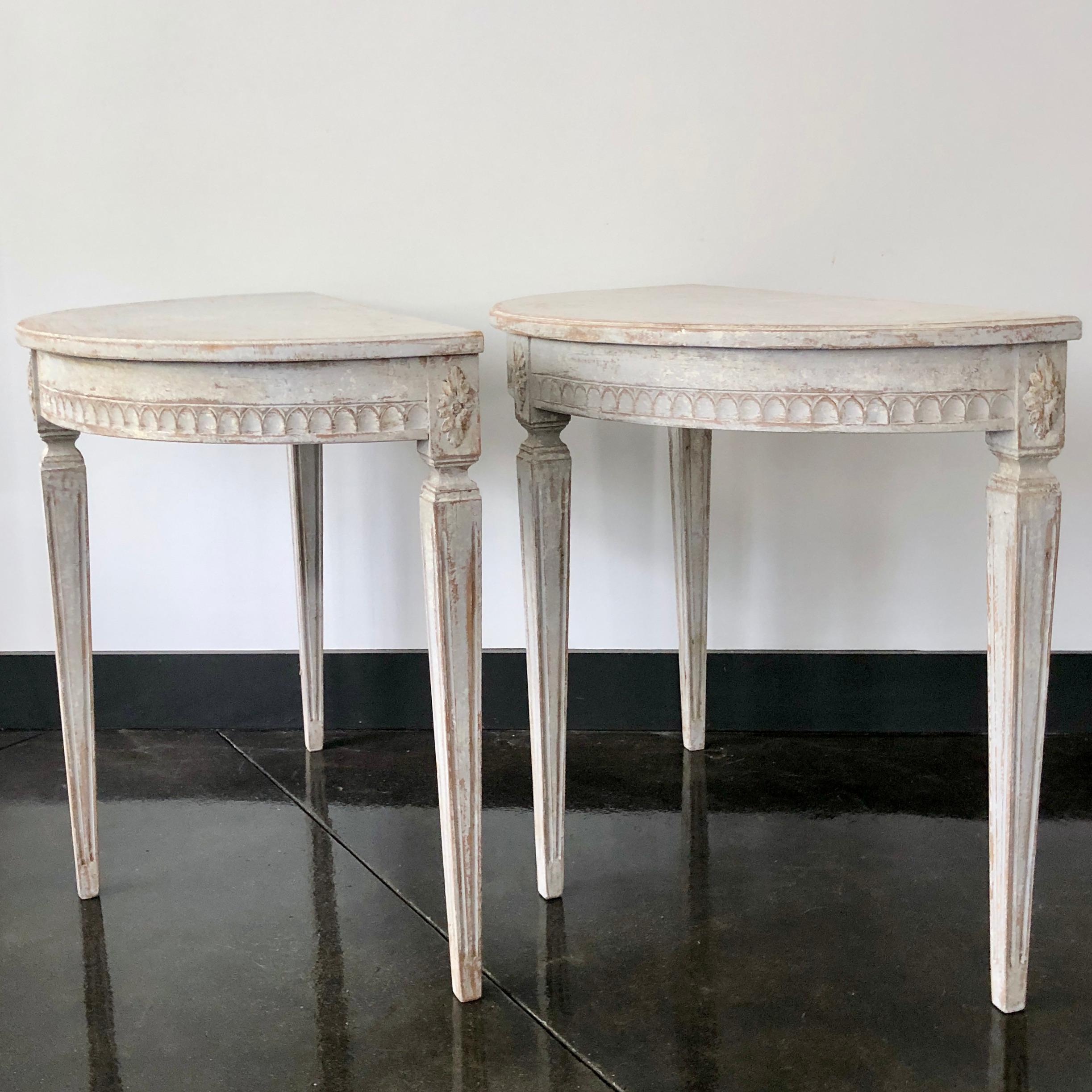 A small charming pair of Swedish Gustavian period demilune console tables beautifully carved apron with Lamb's tongue molding and florets on the corner blocks. Elegant tapered and fluted legs.
Stockholm, Sweden, circa 1810.
 