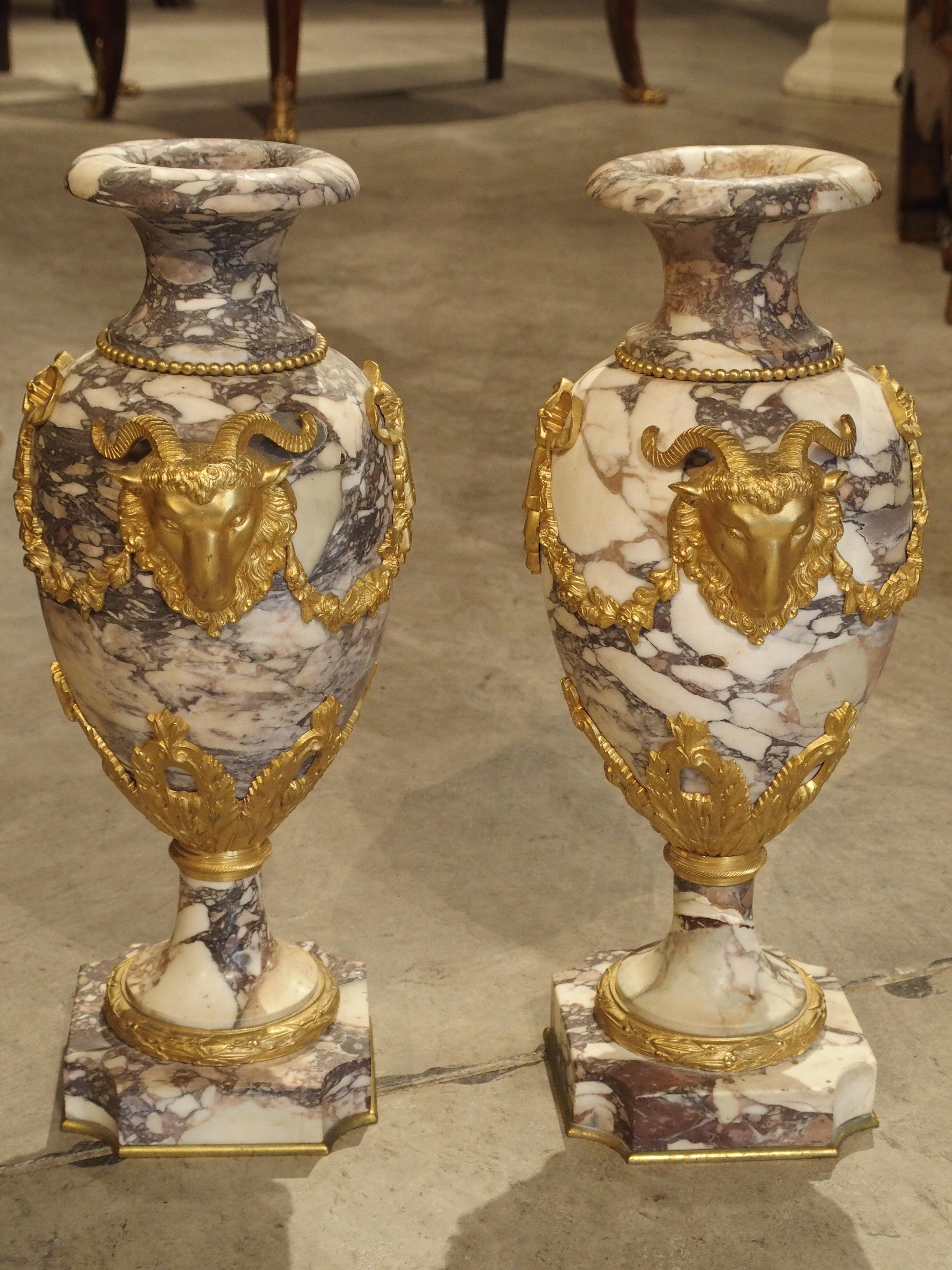 The variegated marble on these French cassolettes is absolutely stunning. They are mix of white, mauve, cream, and purple. Coupled with the gilt bronze embellishments, which are equally impressive, this pair of Period Napoleon III cassolettes will