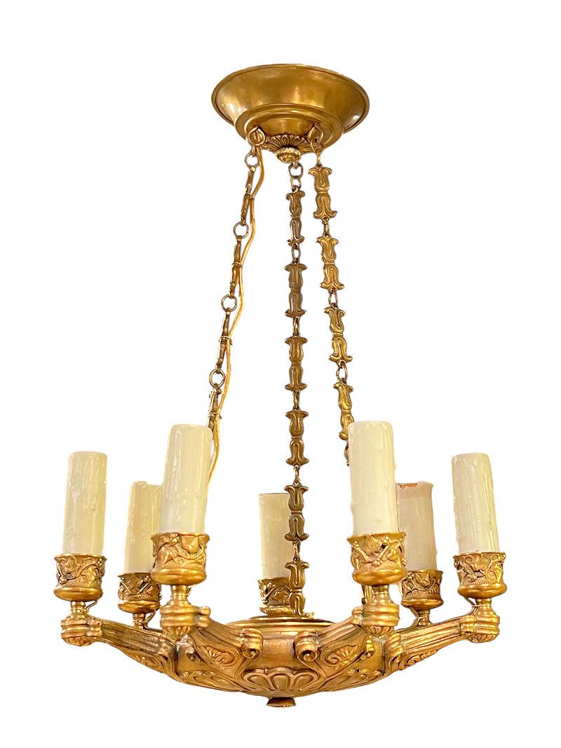 Pair of French  petite gilt bronze chandeliers in the French Empire style with seven candelabra size sockets, wax candle covers, and wiring, ready for use.  16 inches tall and 11 inches across.