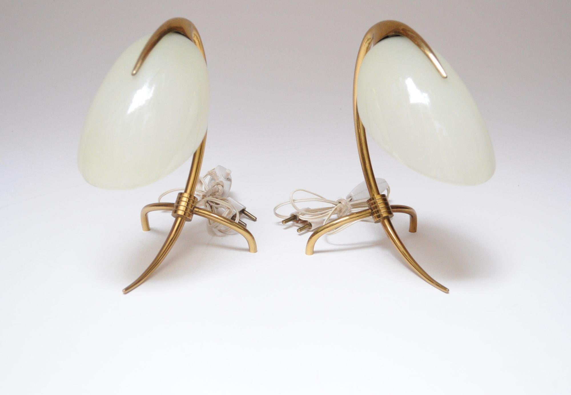 Piccole lampade da comodino/tavolo disegnate da Oscar Torlasco per Lumen Milano (1950 circa, Italia).
Composto da telai curvi in ottone profondamente scolpiti che formano una base a treppiede e un piano a 